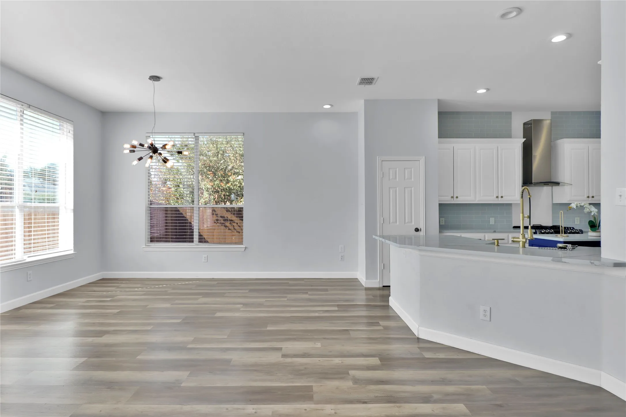 Breakfast area with lots of natural light leading to kitchen with breakfast bar.