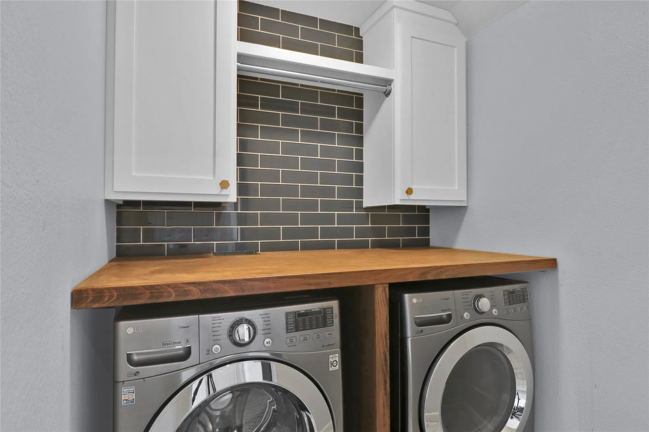 Laundry room with built in cabinets and hanging rack.
