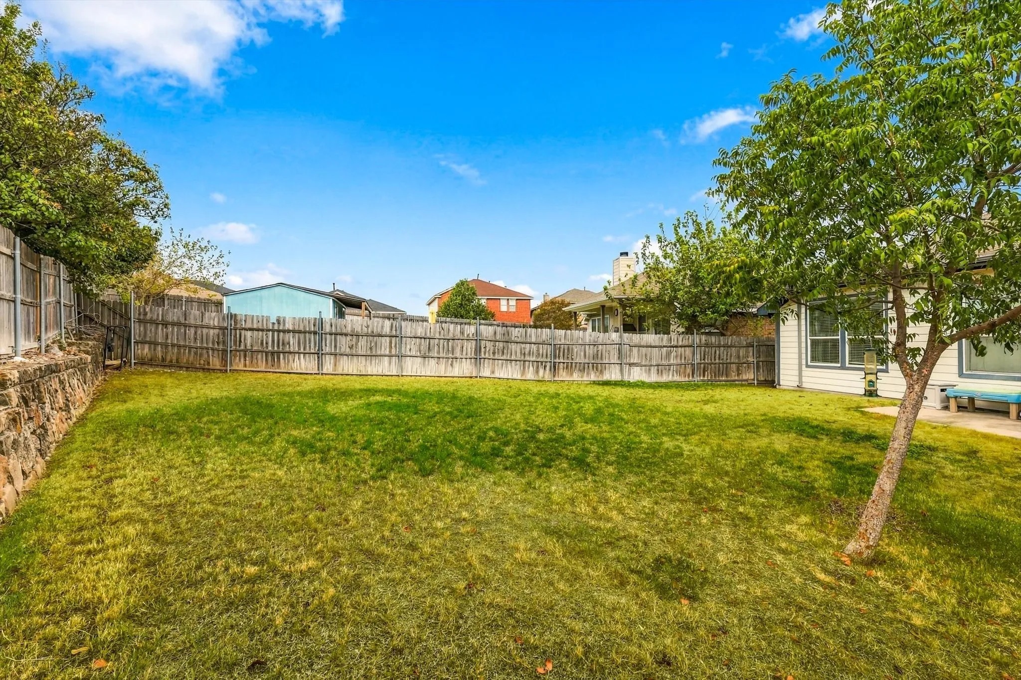 Expansive grass lawn with a full privacy fence