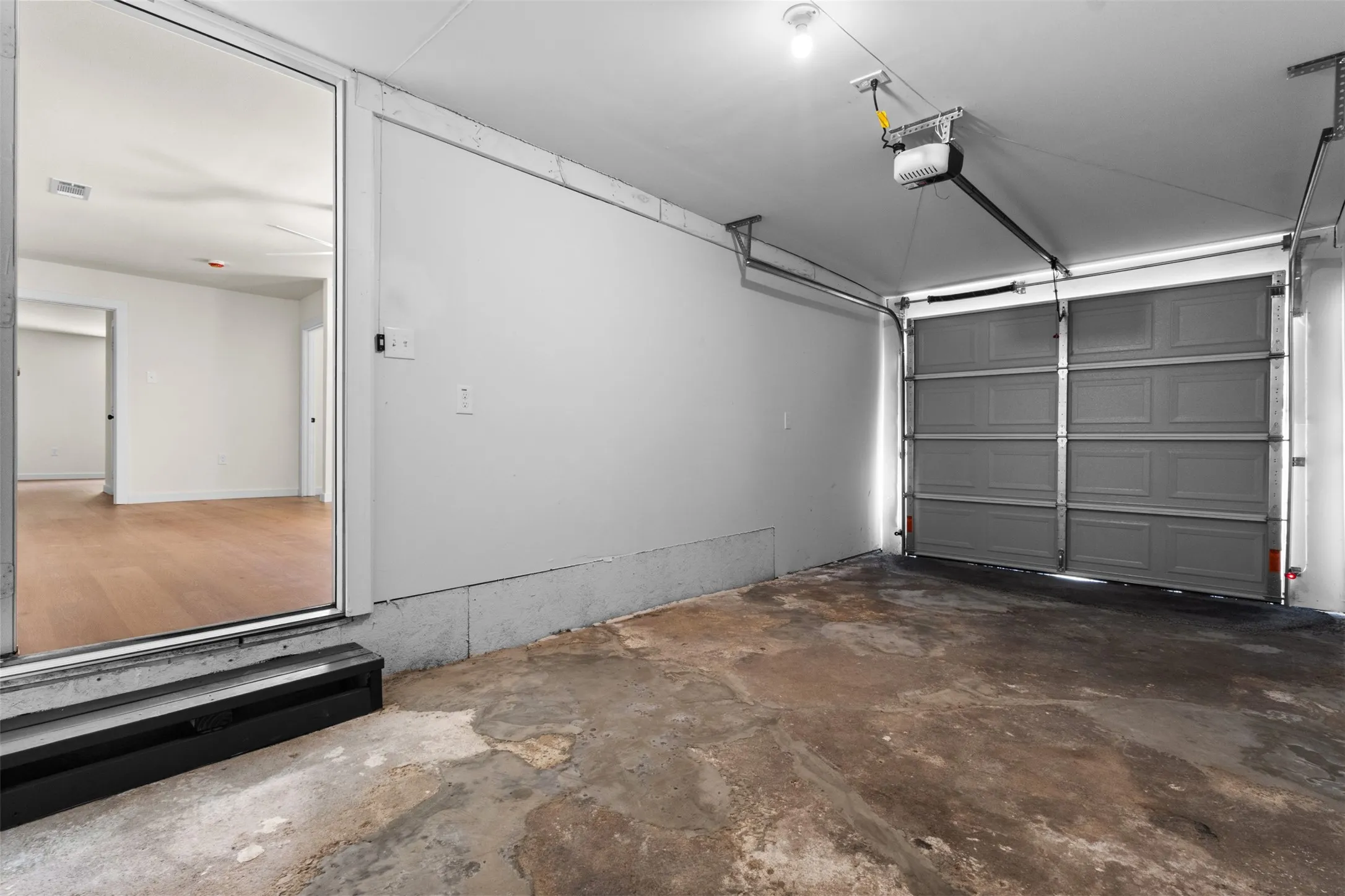 Integrated garage space with an automatic overhead door opener and direct interior access