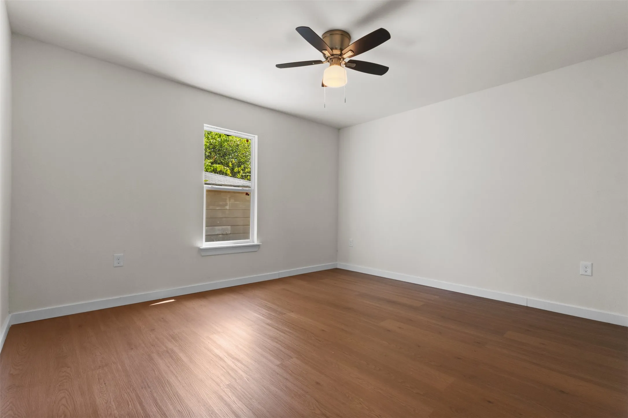 Wood-finish flooring with white baseboards