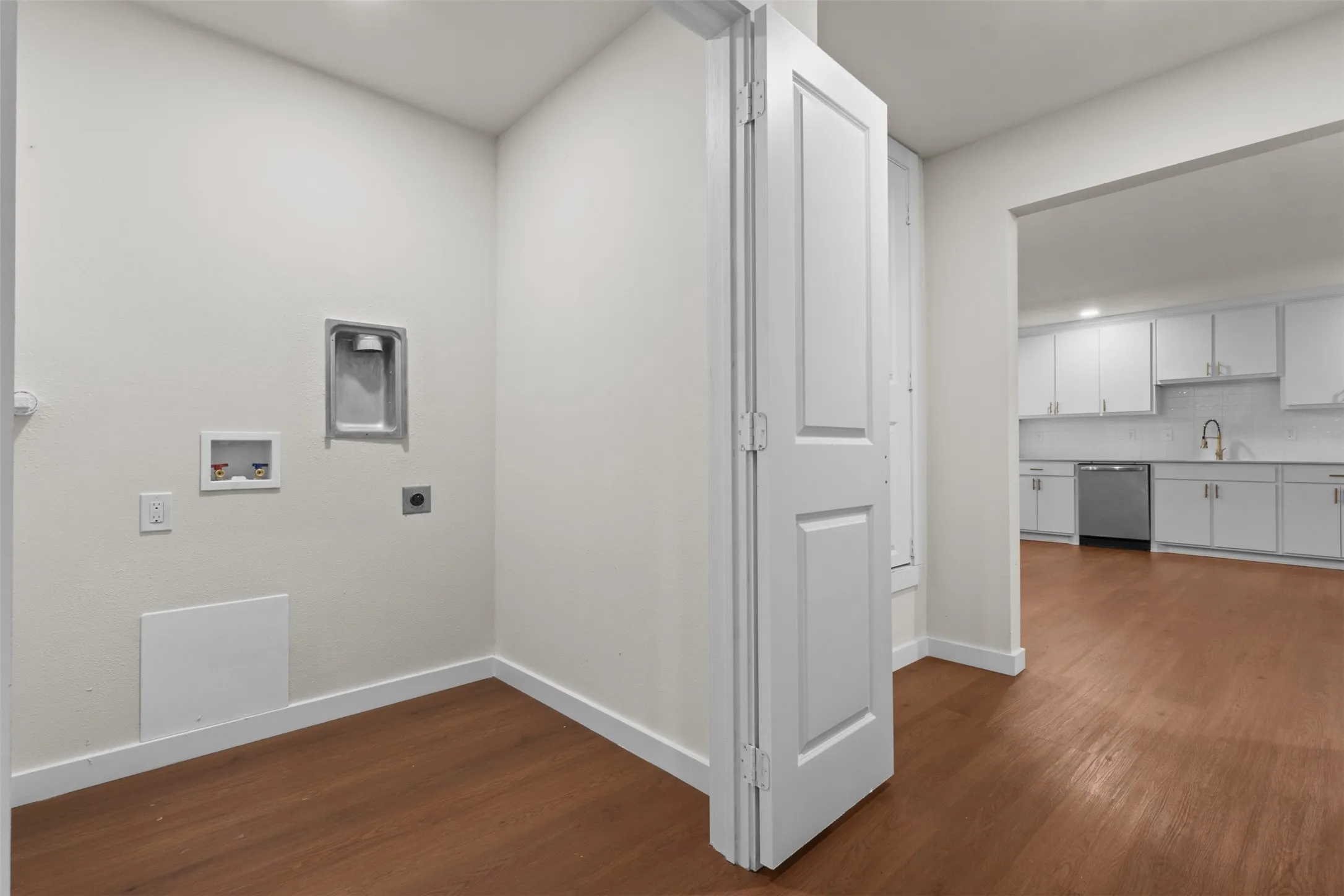 Laundry area with wood-finish flooring