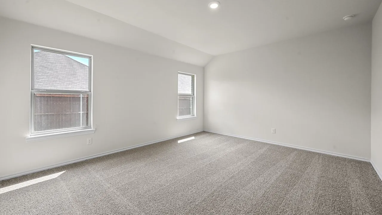 Vaulted ceiling with recessed lighting, two windows with white trim, and gray carpet