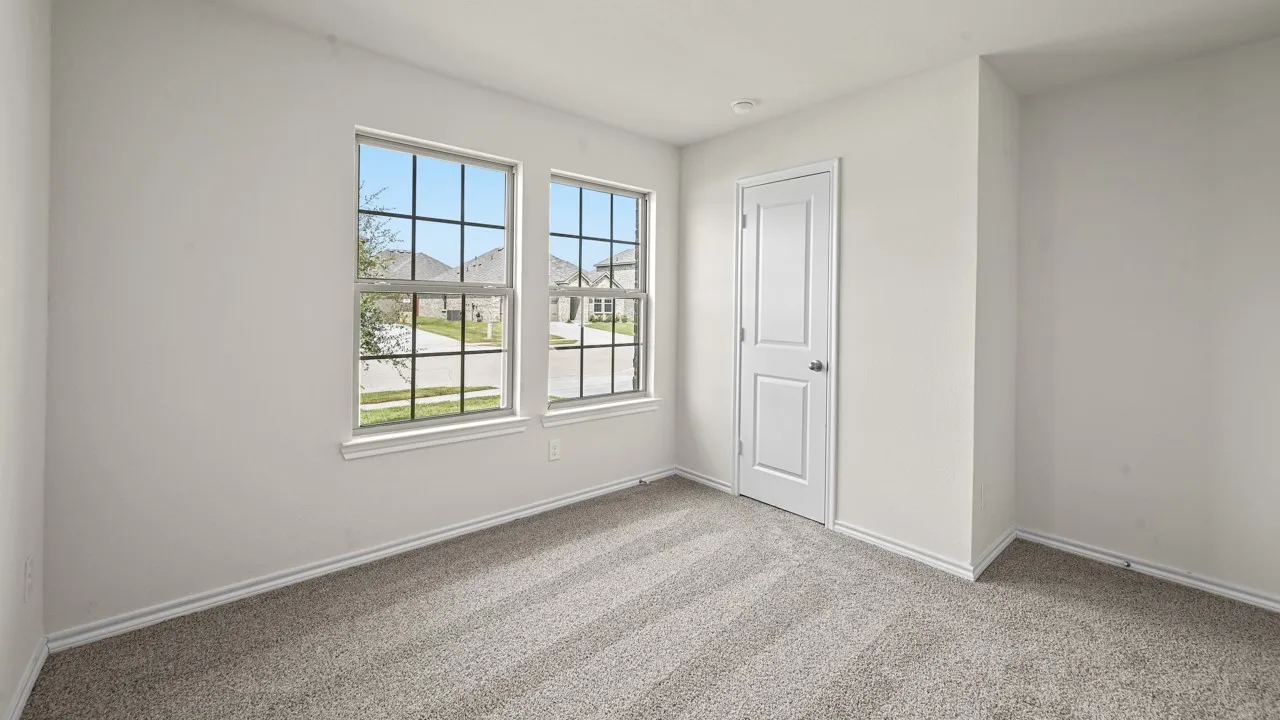 Neutral white walls, plush carpet flooring, two paneled windows with grids, and a white paneled door