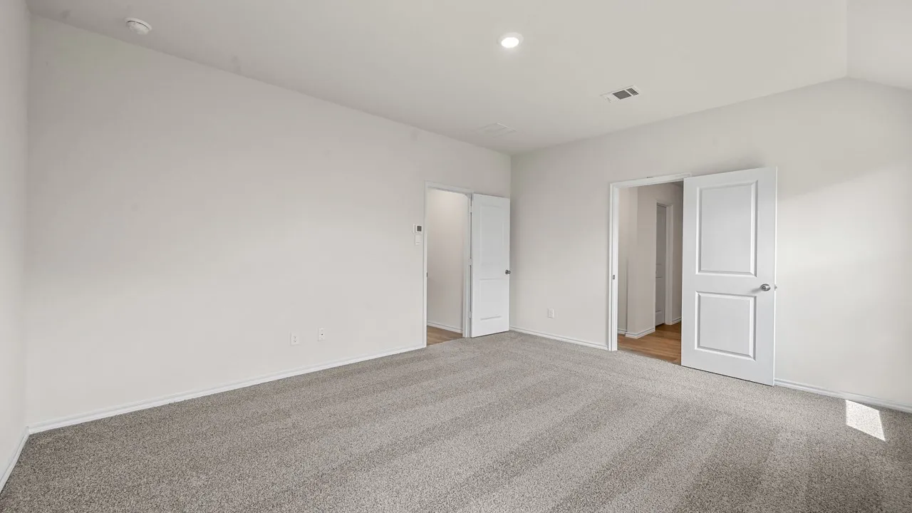 Spacious room featuring vaulted ceilings, light gray carpeting, recessed lighting, and white paneled doors