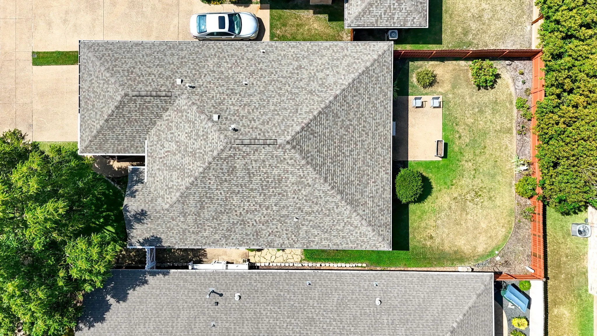 Asphalt shingle roof with multiple vents and a concrete driveway
