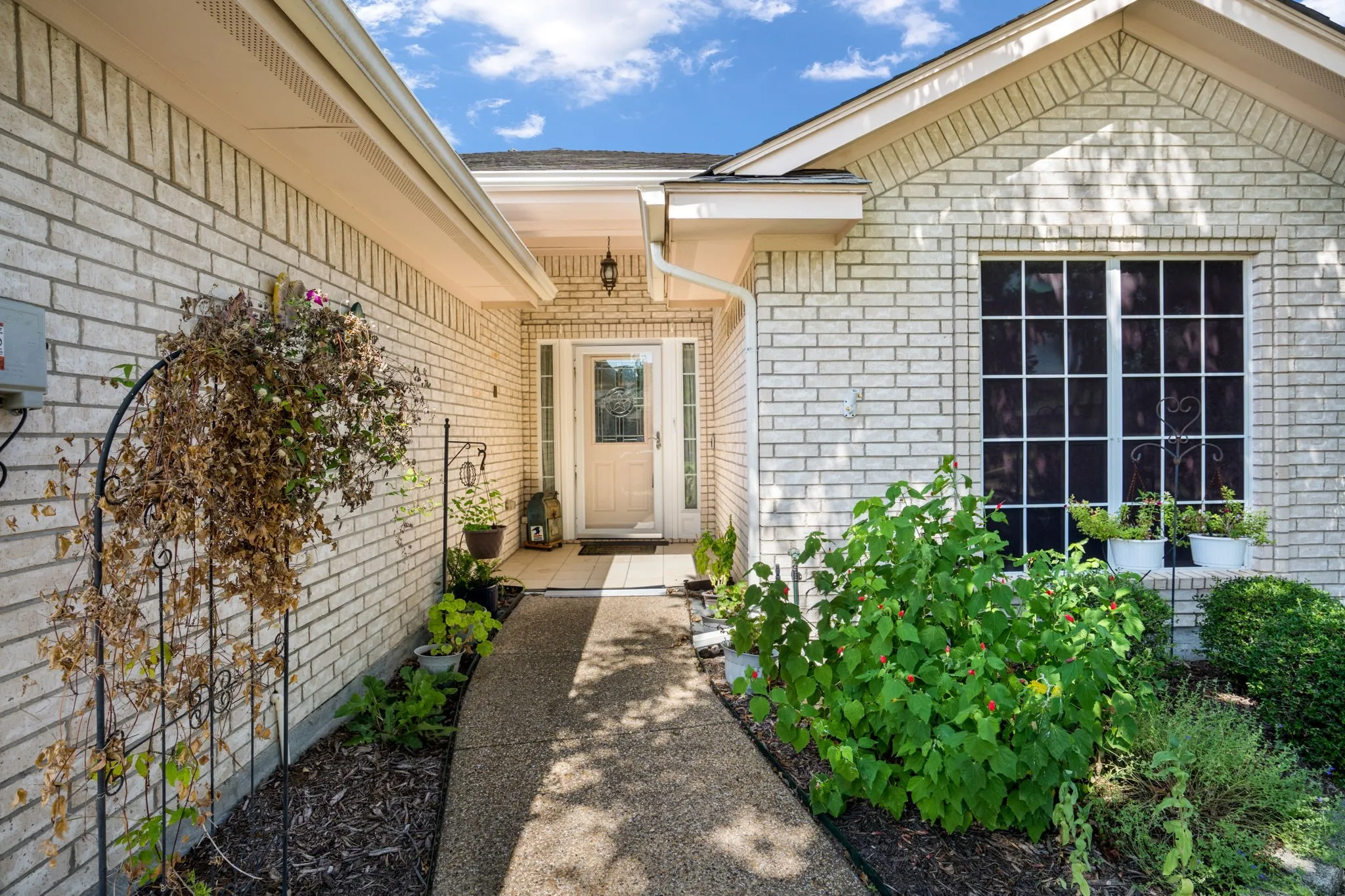 Welcoming brick exterior with white trim detailing and a pitched roofline