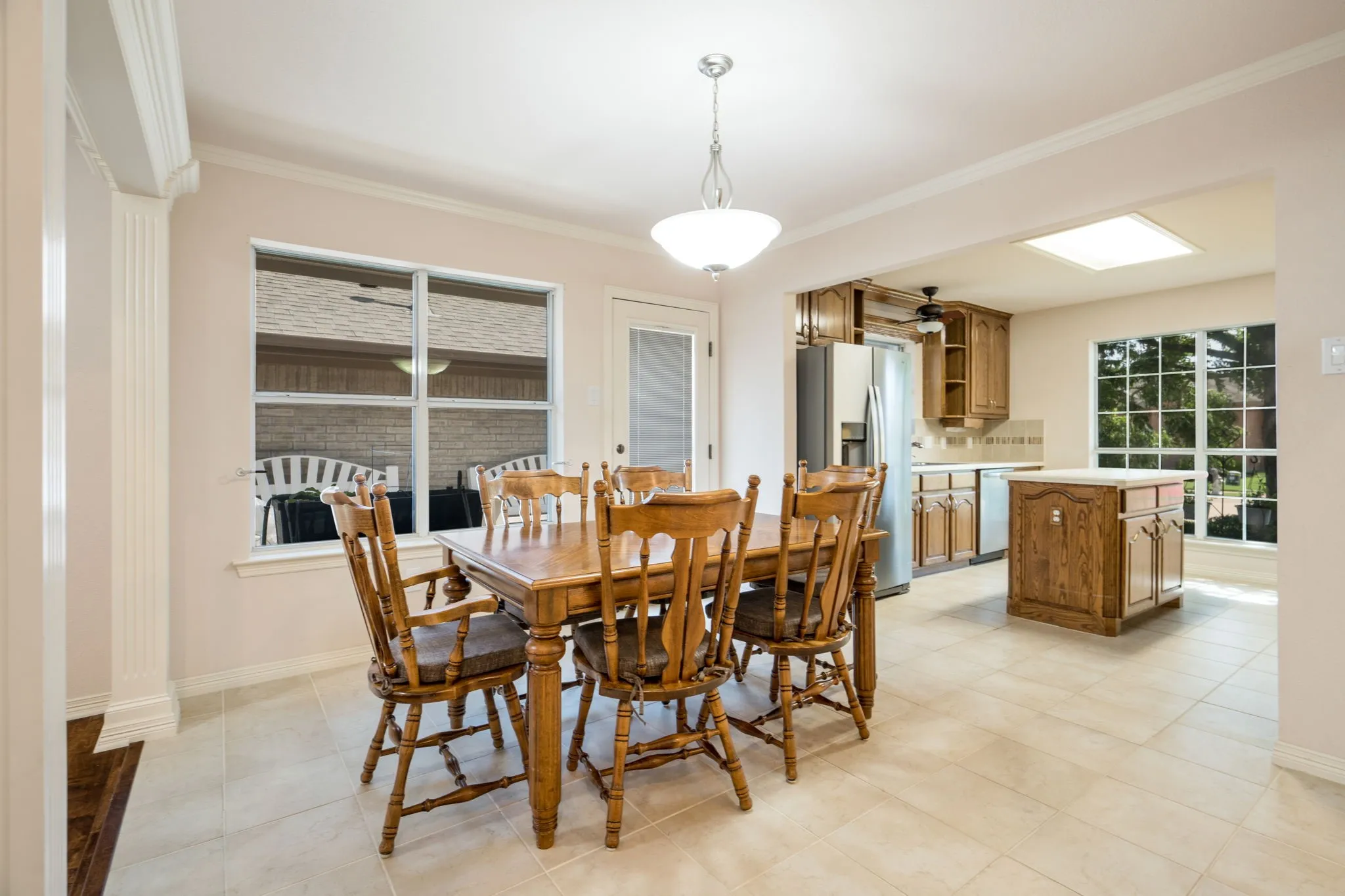 Open-concept dining area with large windows and tiled flooring