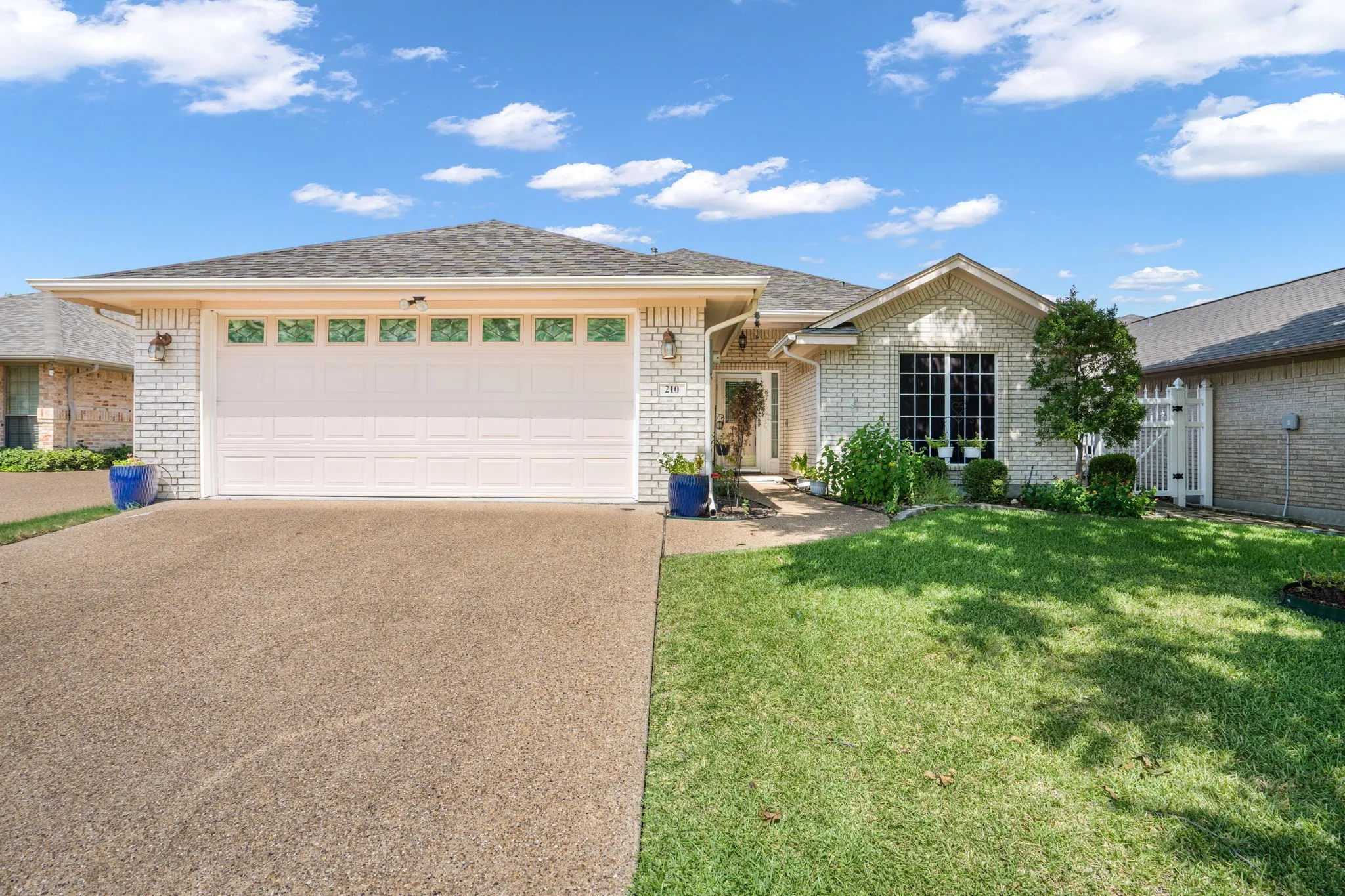 White brick exterior with a gabled roofline and attached garage