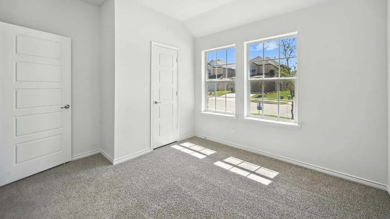 Carpeted flooring, two paneled doors, and two double-hung windows