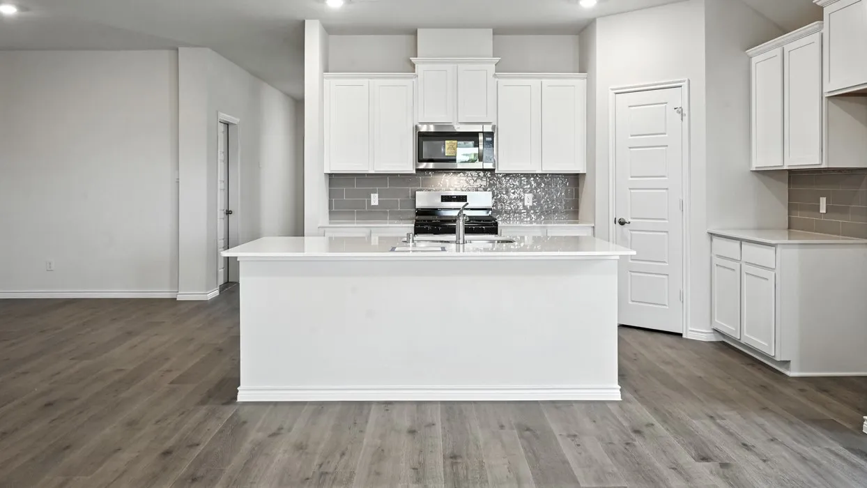 Open-concept kitchen with white cabinetry and an island featuring a dual-basin sink
