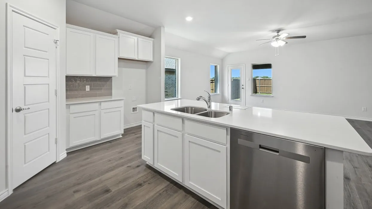 Kitchen featuring an expansive island with a dual-basin sink, stainless steel dishwasher, white cabinetry, and wood-finish flooring