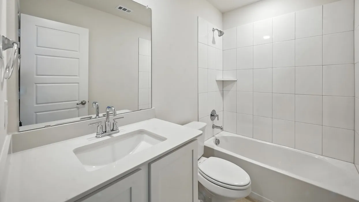 Vanity with an integrated sink, polished chrome faucet, and expansive mirror