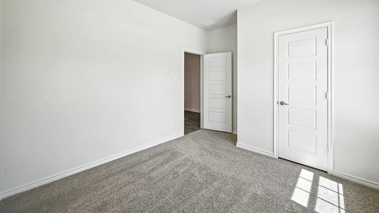 Neutral tone wall paint, gray patterned carpeting, white five-panel interior doors, and crisp white trim