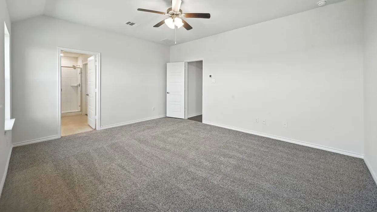 Spacious room with vaulted ceilings and neutral-toned carpeting