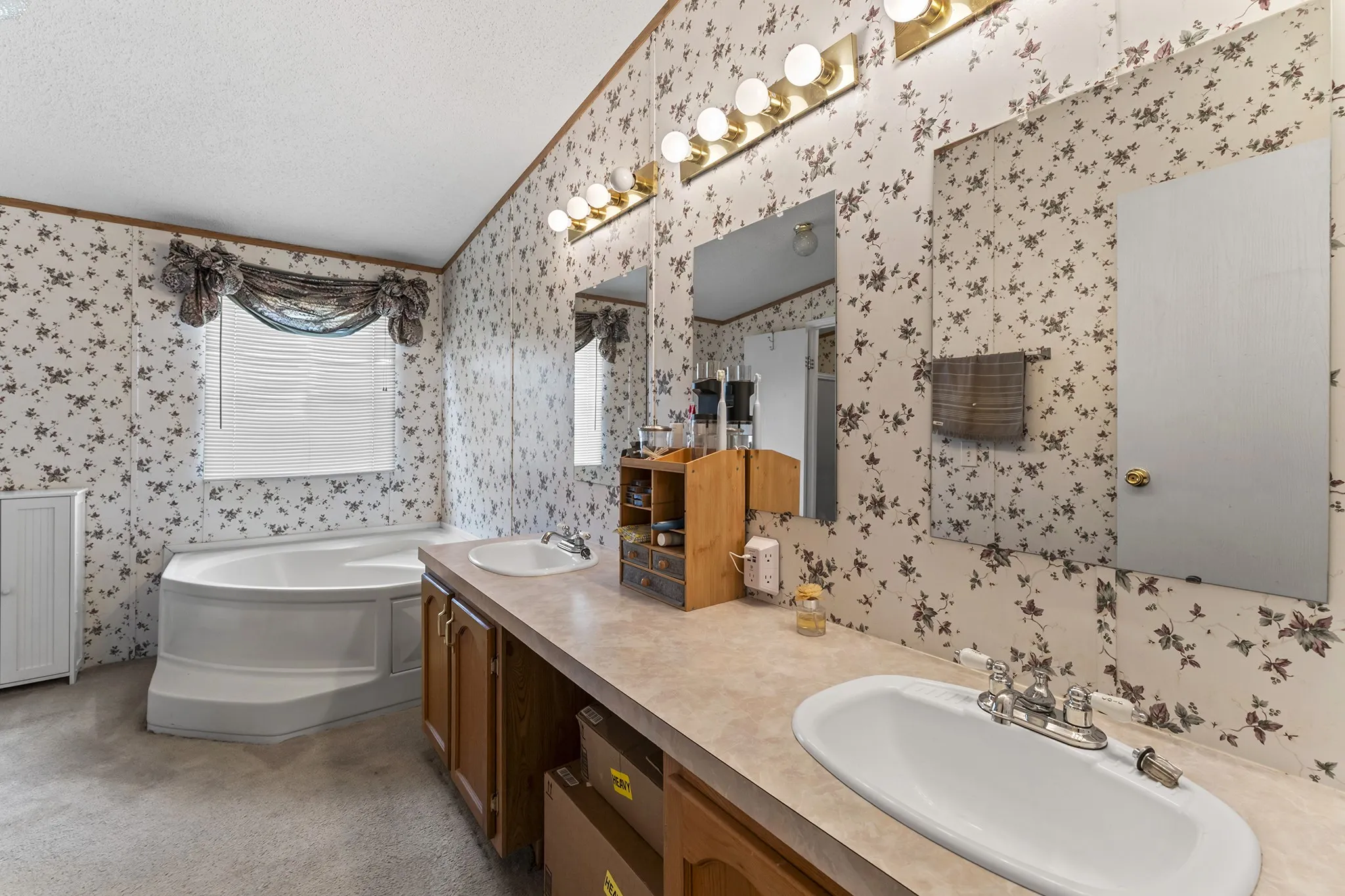 Dual vanity with integrated sinks, corner soaking tub, and wallpapered walls
