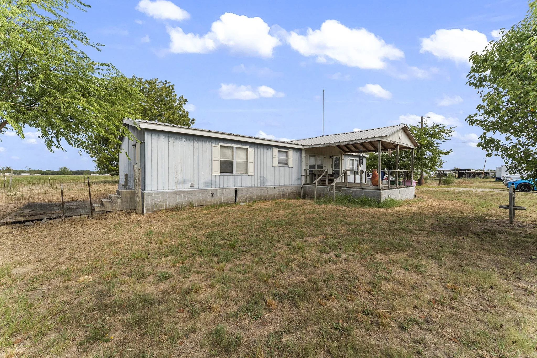 Property featuring a covered porch, wood exterior accents, and a metal roof