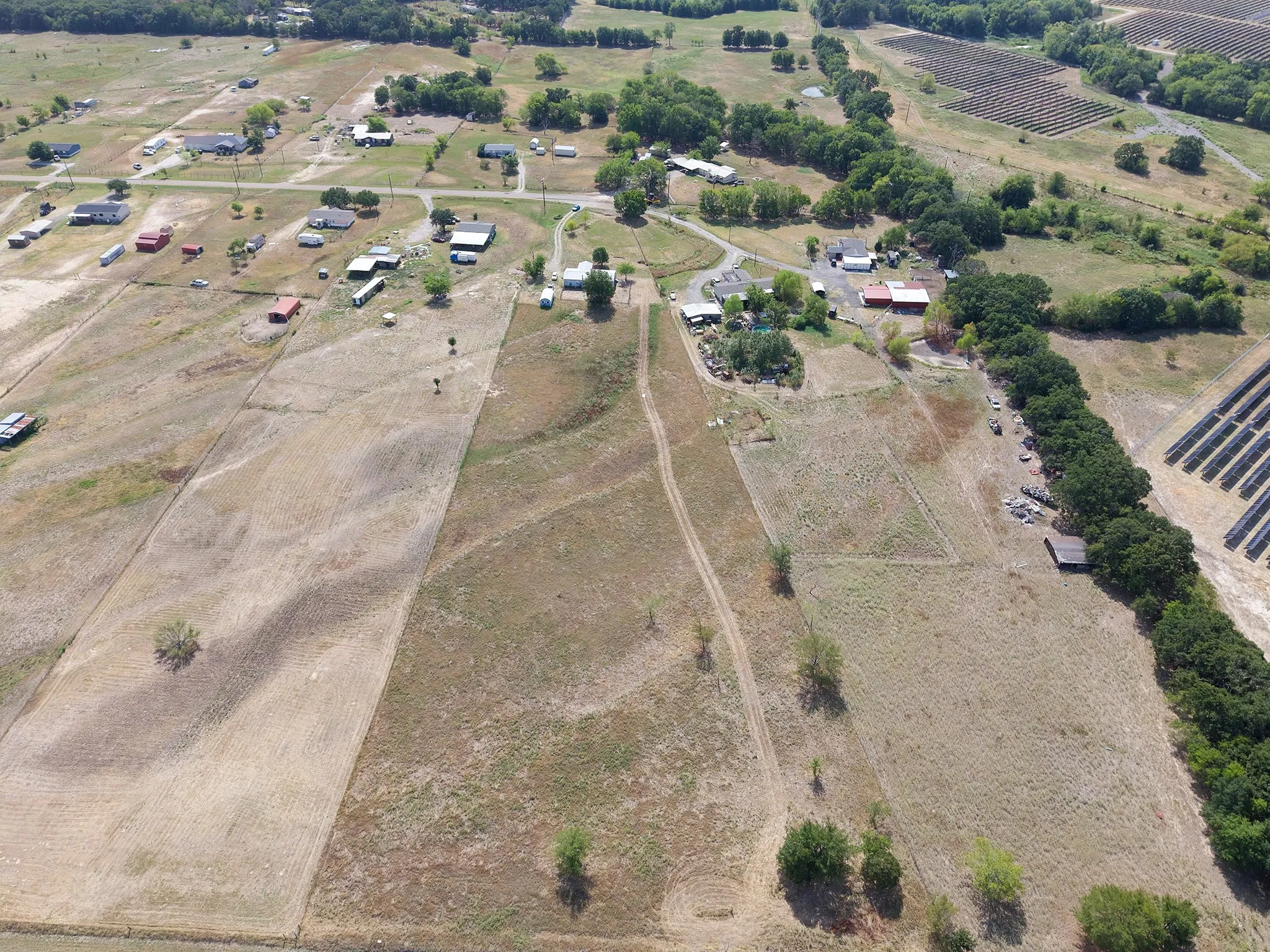 Expansive rural landscape featuring multiple parcels, scattered residences, and mature tree lines