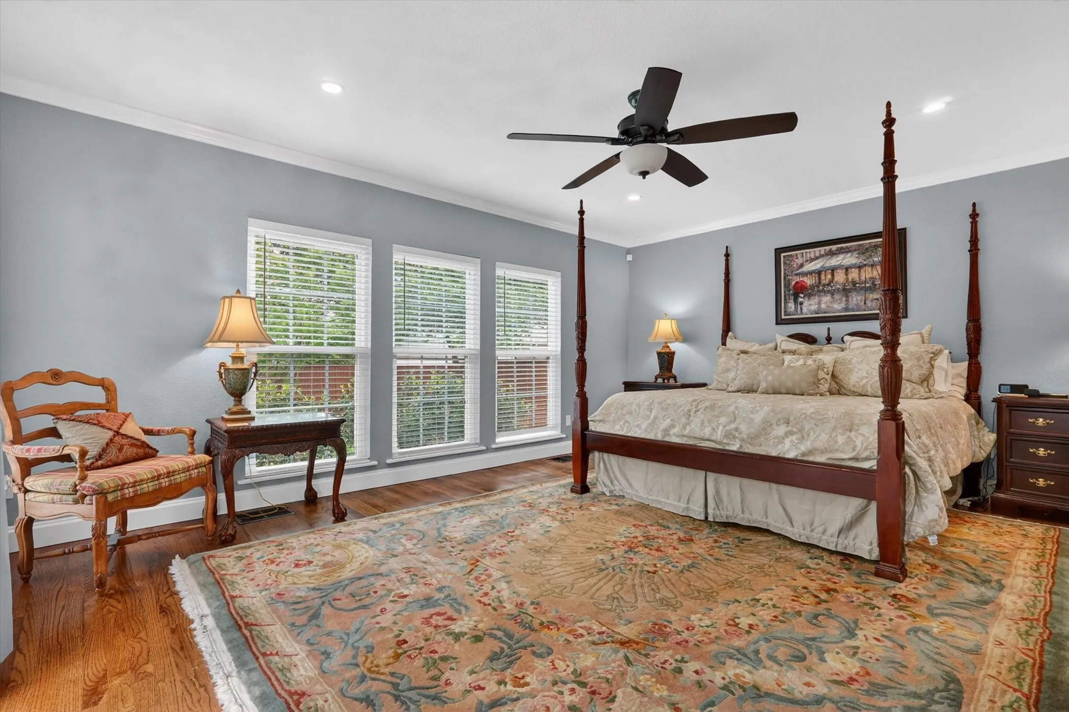 Room featuring warm wood flooring, crisp white crown molding, recessed lighting, and a ceiling fan