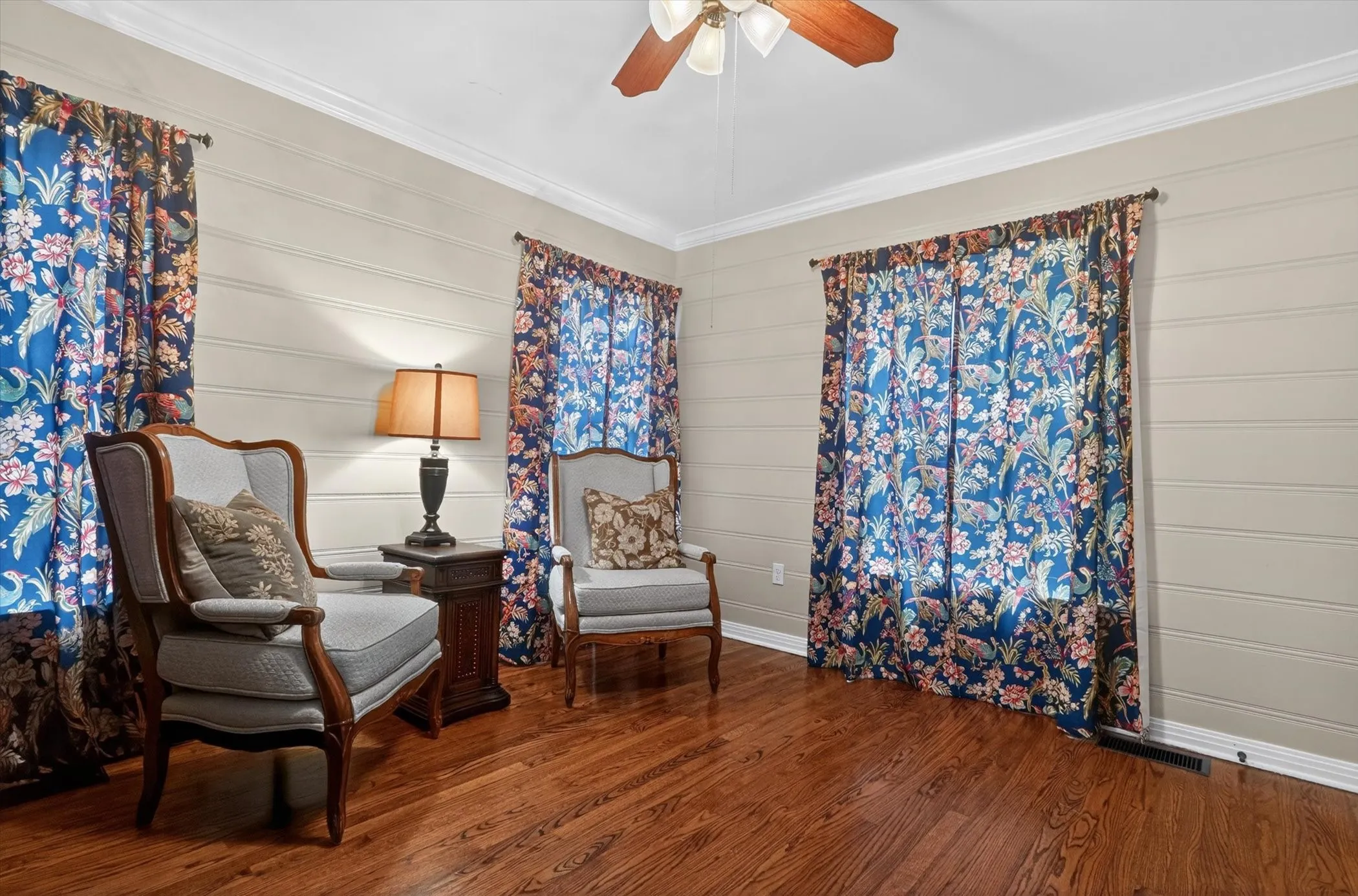 Warm wood-finish flooring complements horizontal shiplap walls with crisp white crown molding