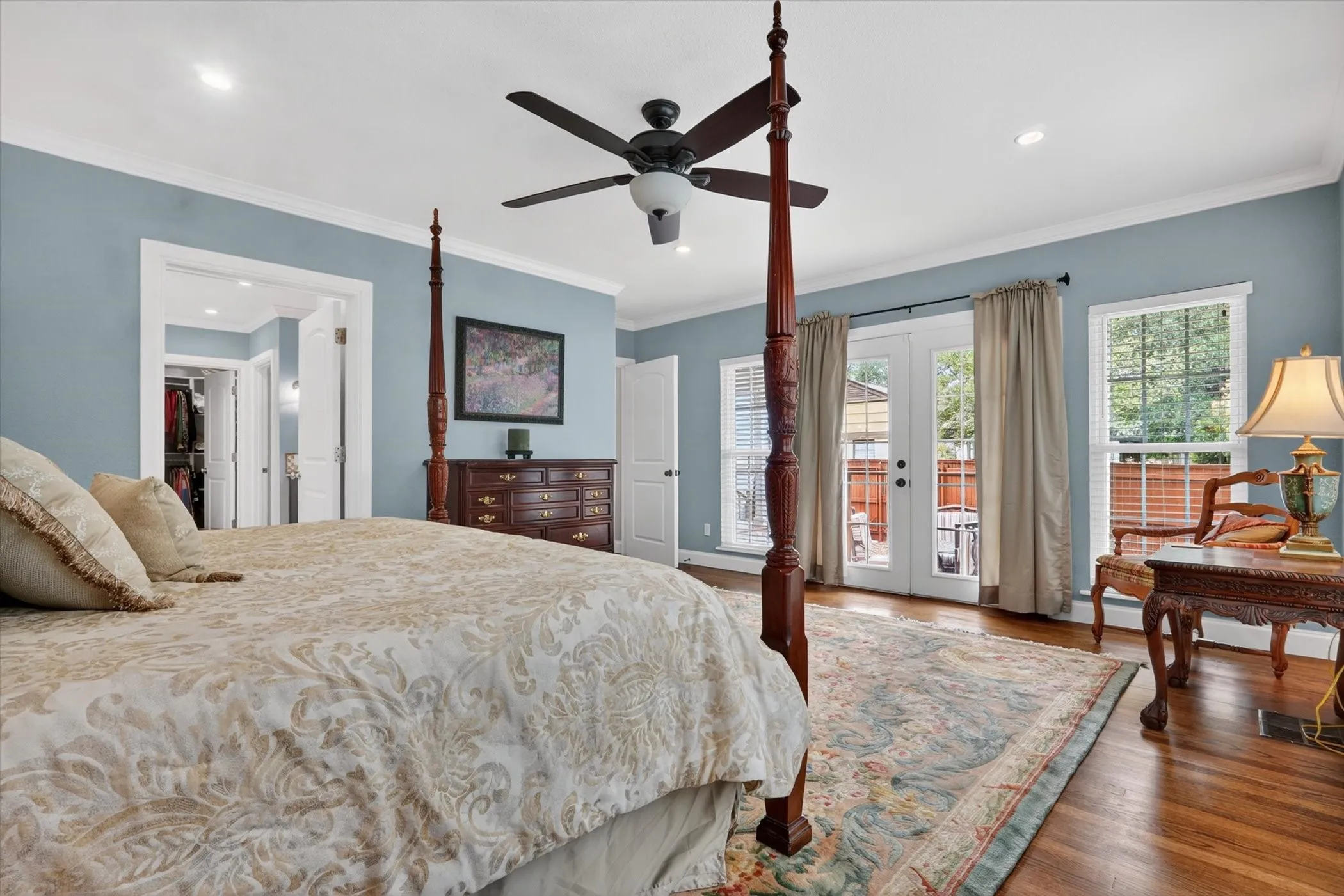 Hardwood flooring throughout featuring recessed lighting, a ceiling fan, crown molding, and double glass-paneled doors with transom windows