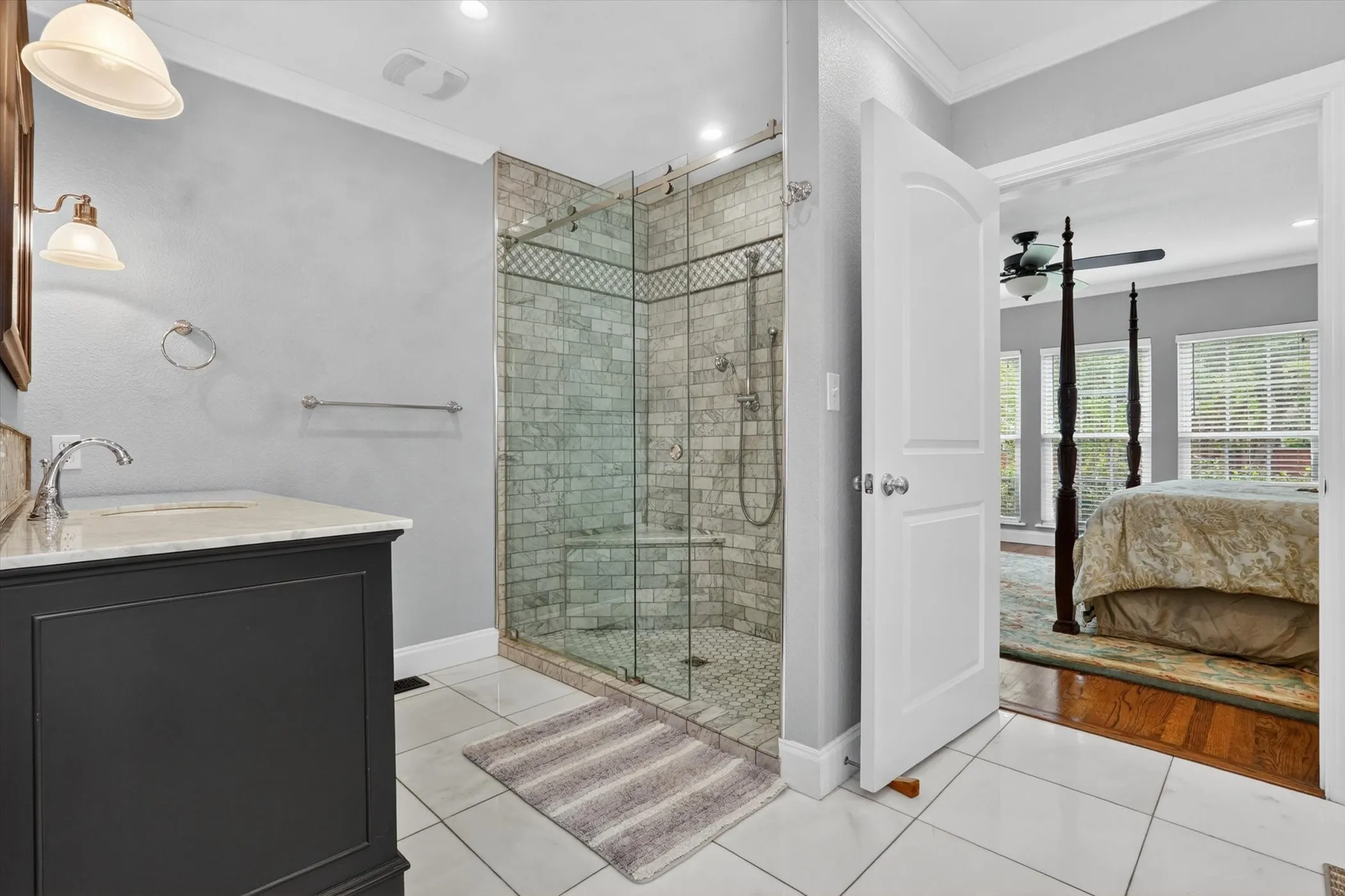 Glass-enclosed shower with subway tile surround and mosaic accent