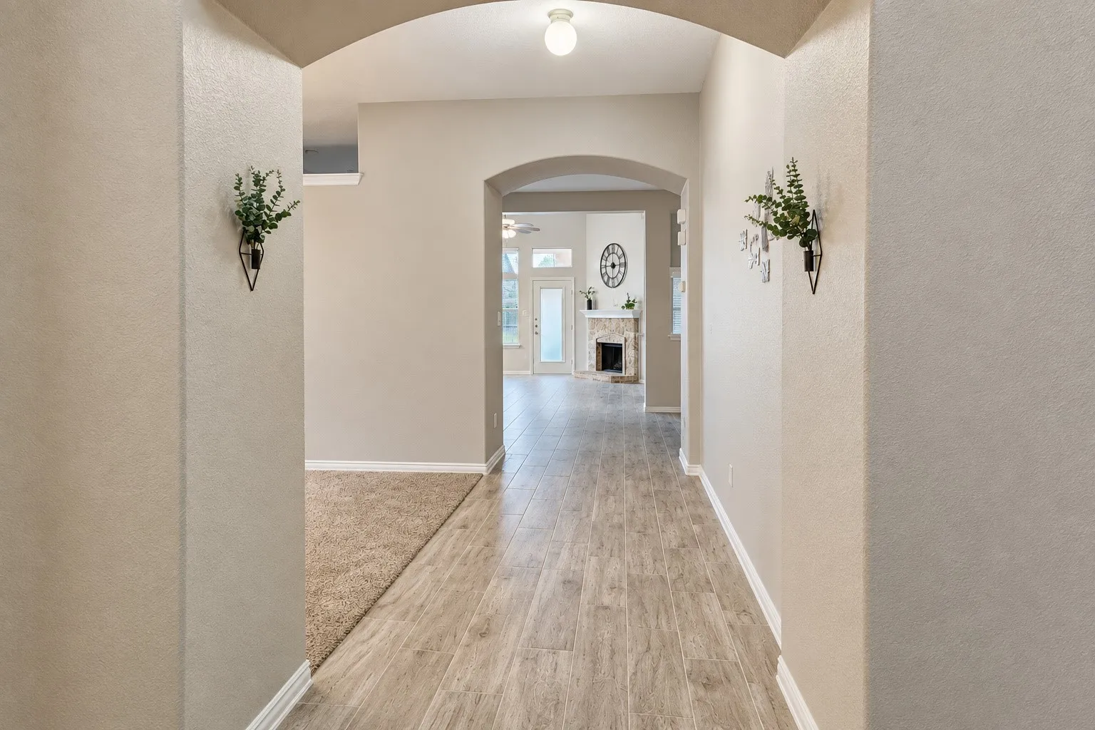Arched hallway entry with wood-finish flooring