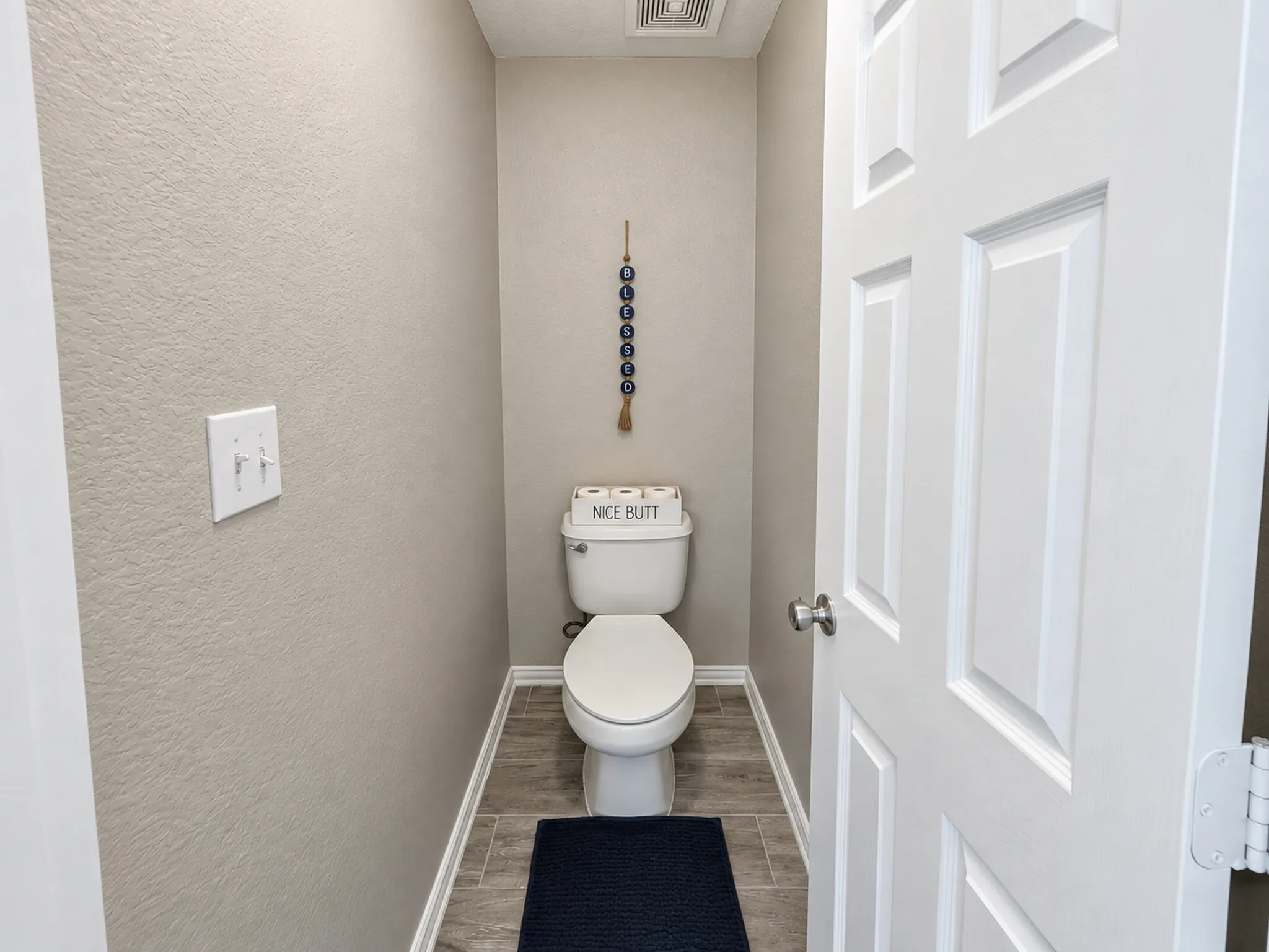 White paneled door, ceramic tile flooring, and a standard toilet fixture