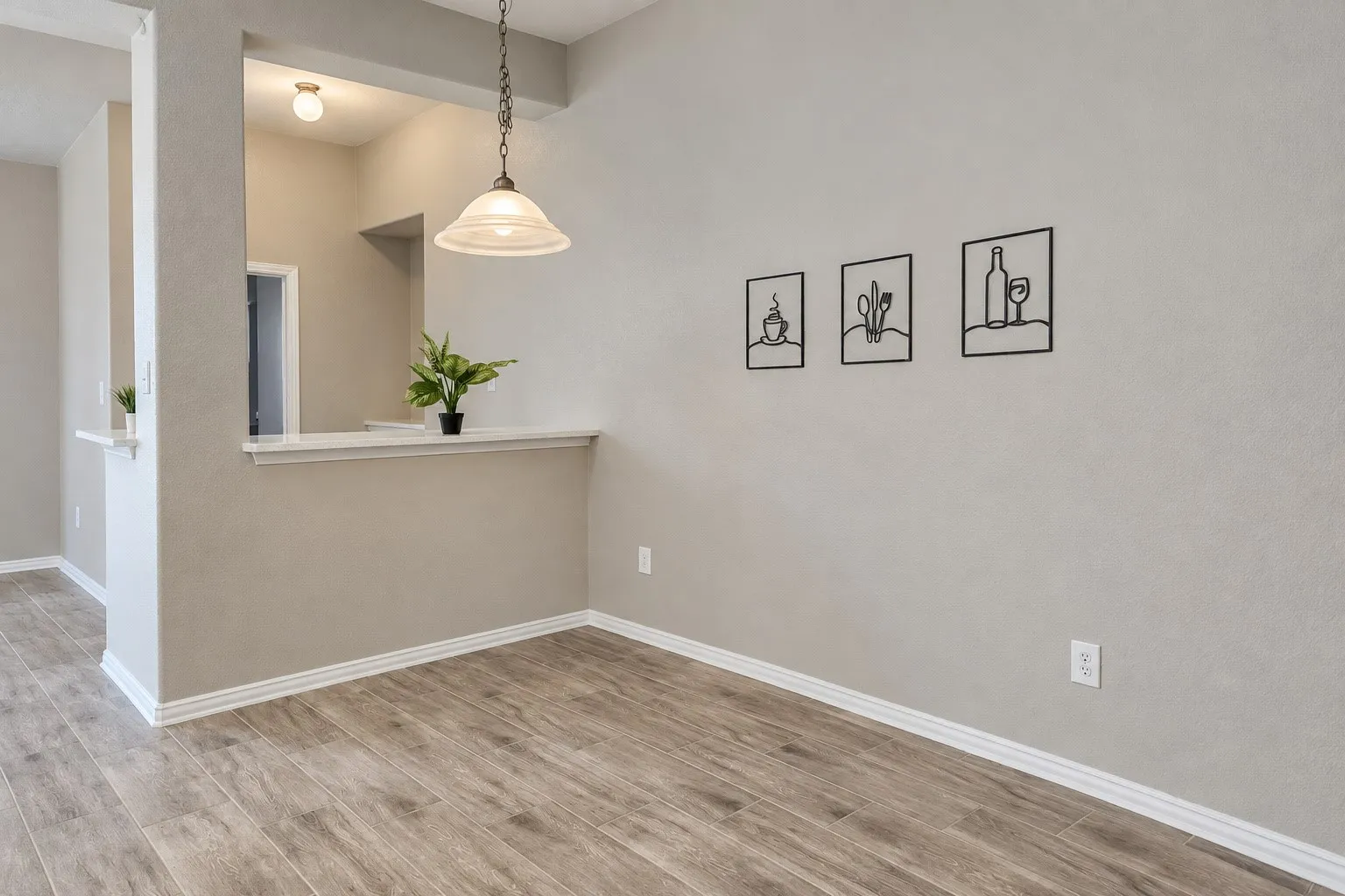 Wood-finish flooring, neutral wall tones, and overhead pendant lighting