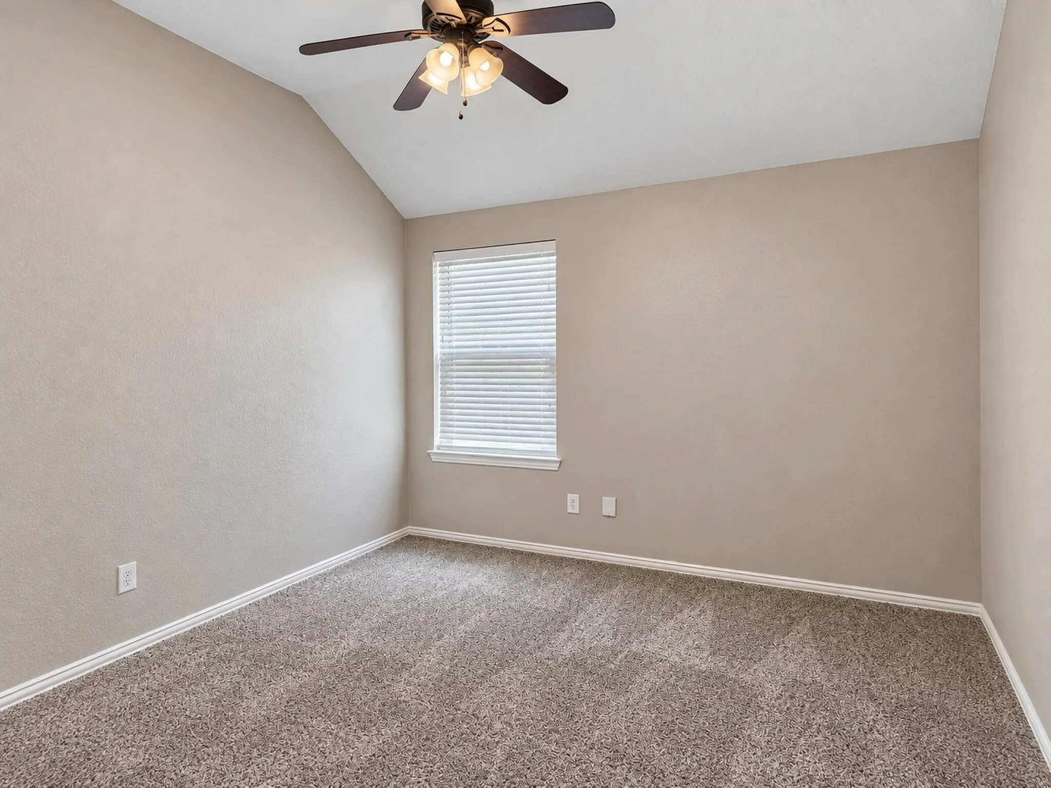 Vaulted ceiling, ceiling fan with integrated lighting, window with blinds, and carpet flooring
