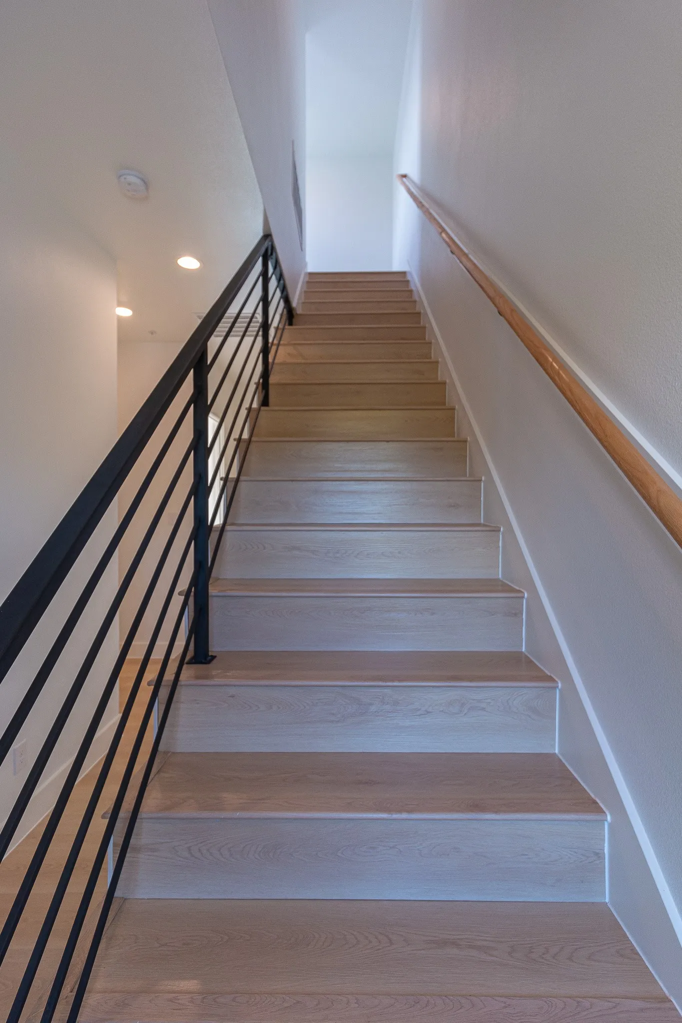 Staircase featuring hardwood / wood-style flooring