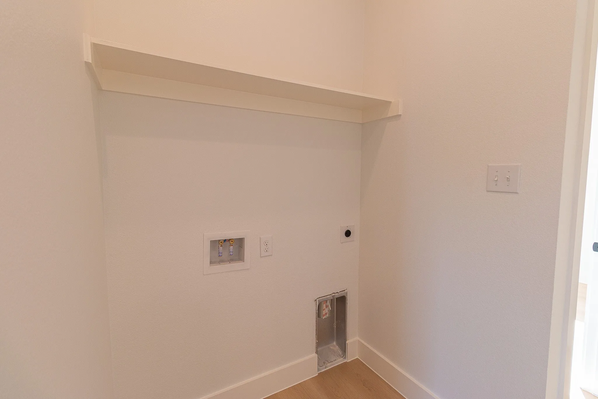 Laundry area featuring hookup for an electric dryer, washer hookup, and hardwood / wood-style flooring