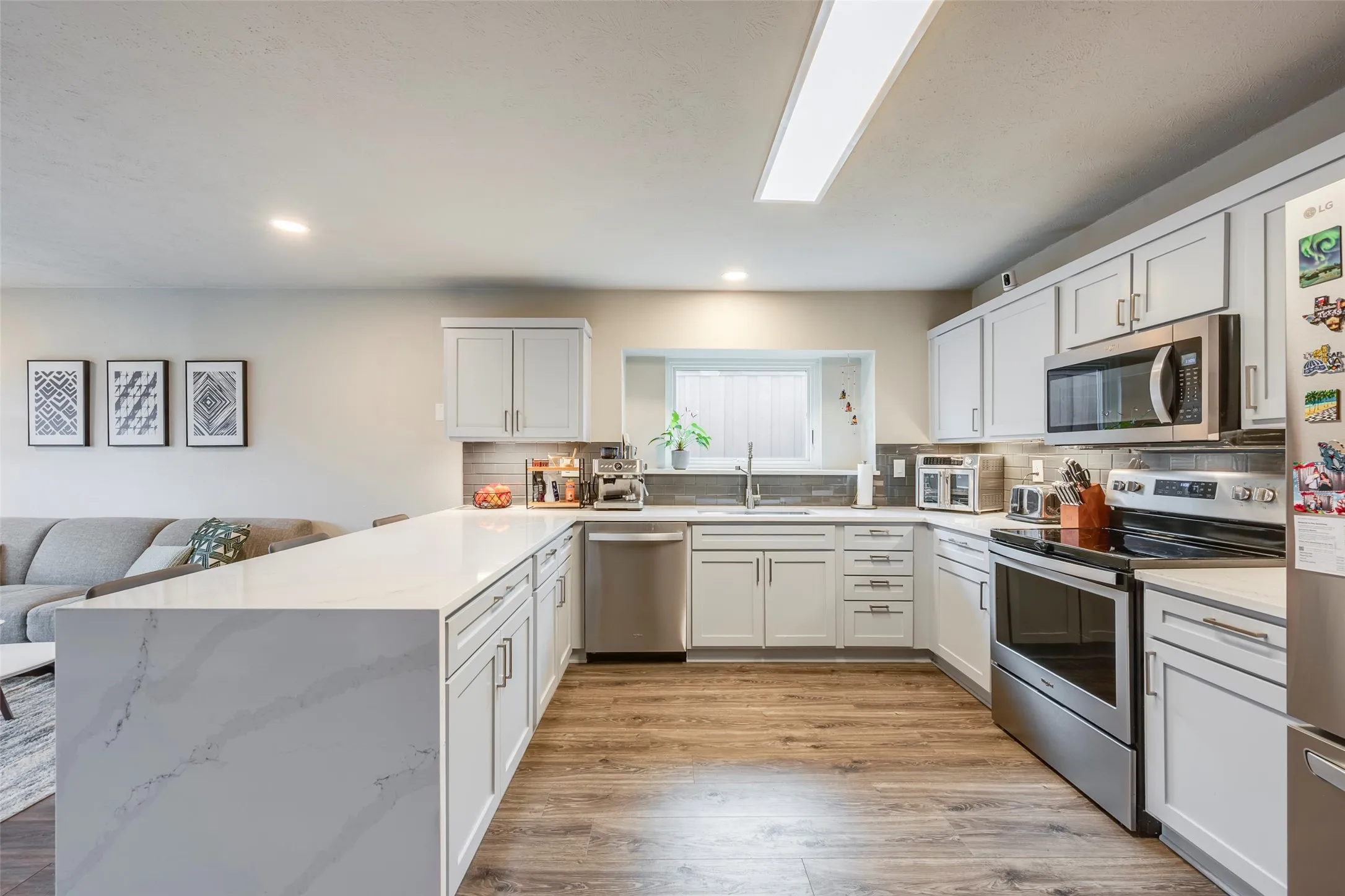 Modern updated kitchen with quartz countertops and stainless steel appliances