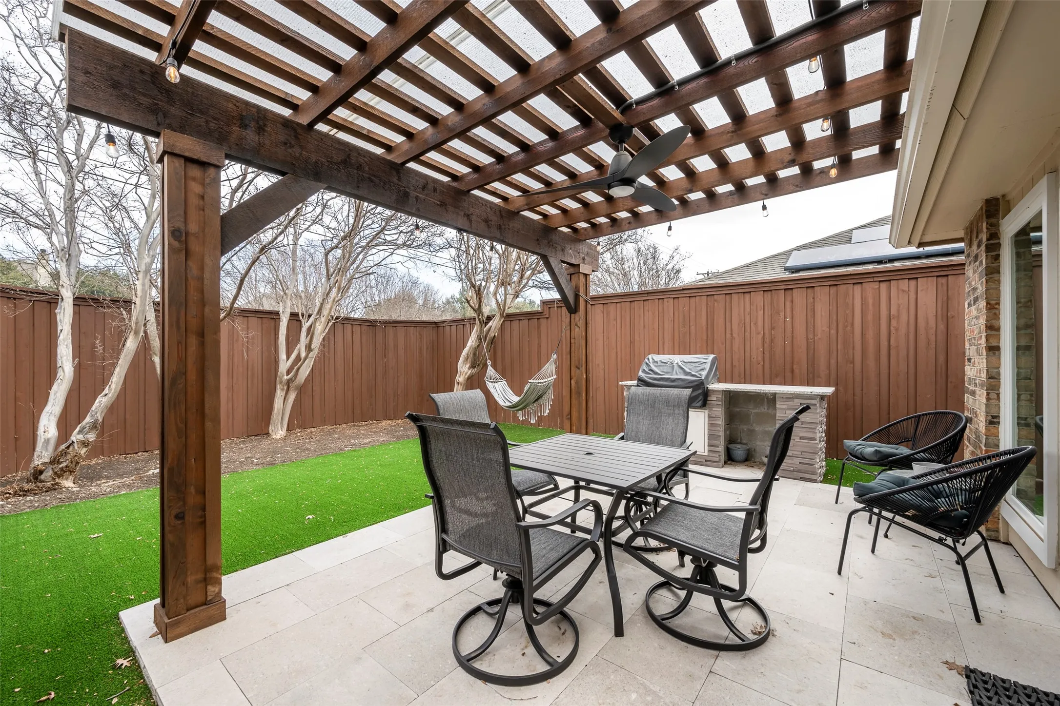 Amazing low-maintenance yard with board on board privacy fence, pergola, BBQ grill and turf