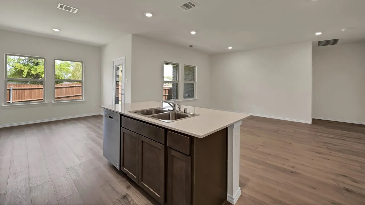 Central kitchen island with an undermount double-basin sink and integrated dishwasher