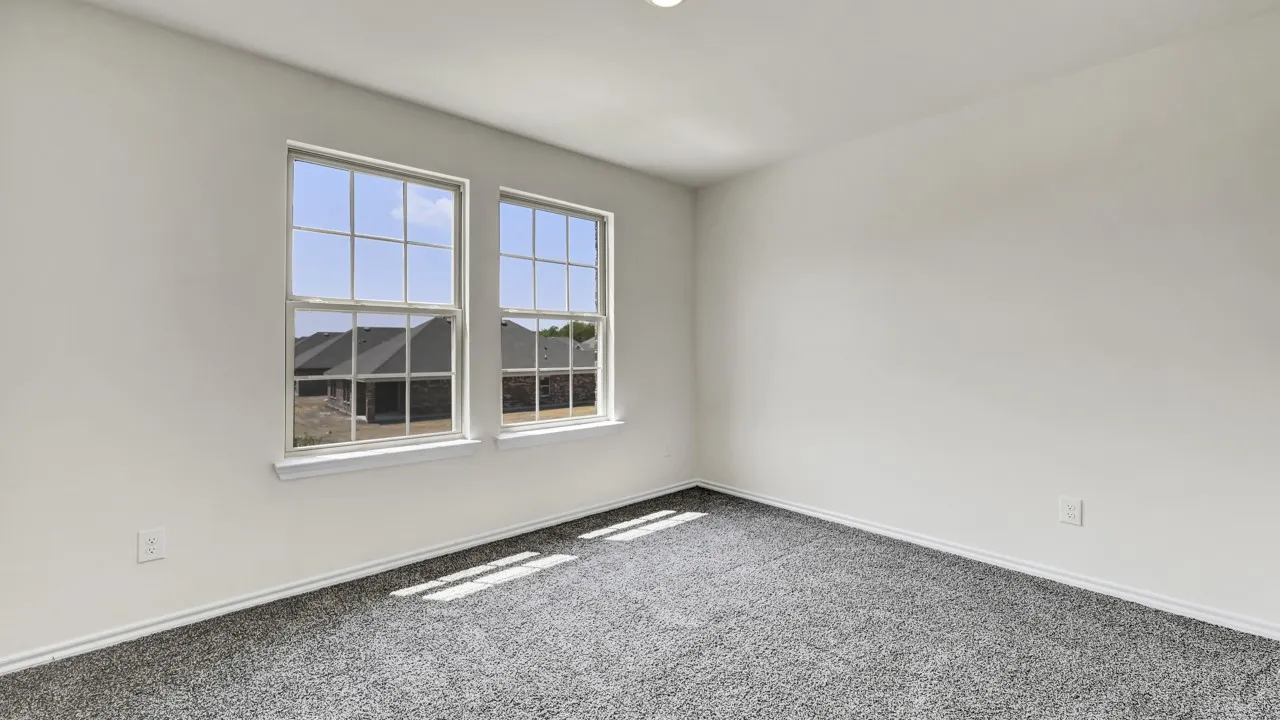 Neutral wall paint, two paneled windows, and gray carpet flooring
