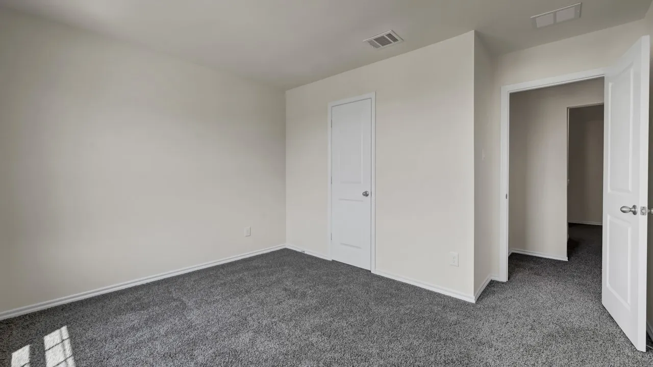 Neutral wall finishes, recessed ceiling vents, grey carpeting, and white interior doors