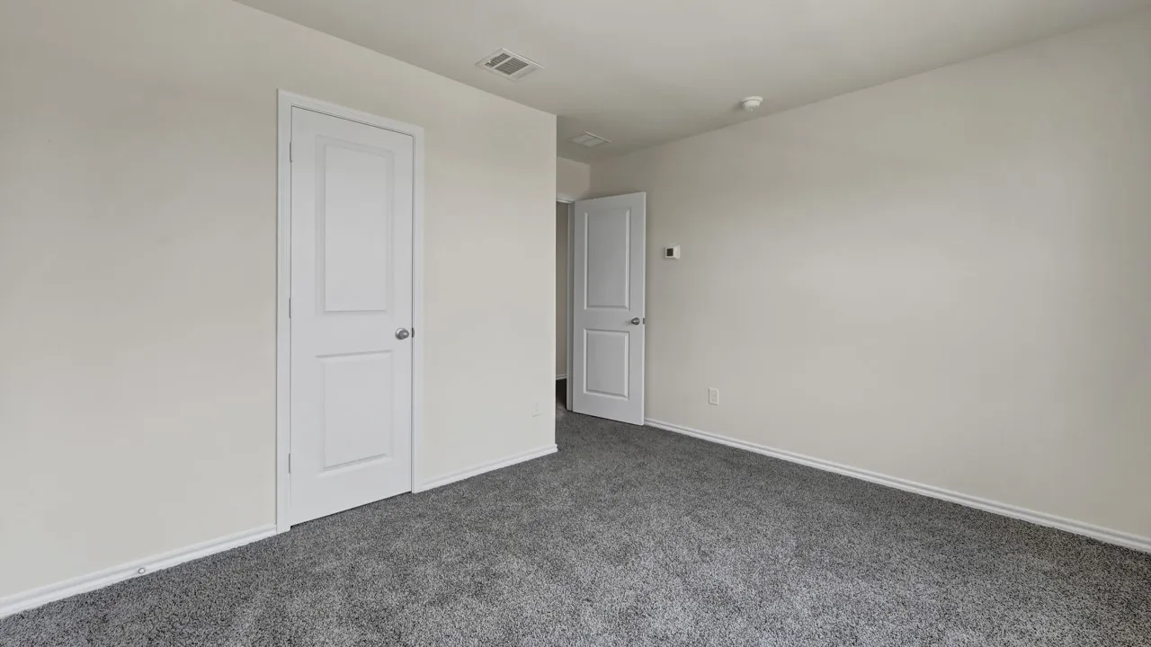 Light gray wall paint, gray carpet flooring, white interior doors, and white trim molding