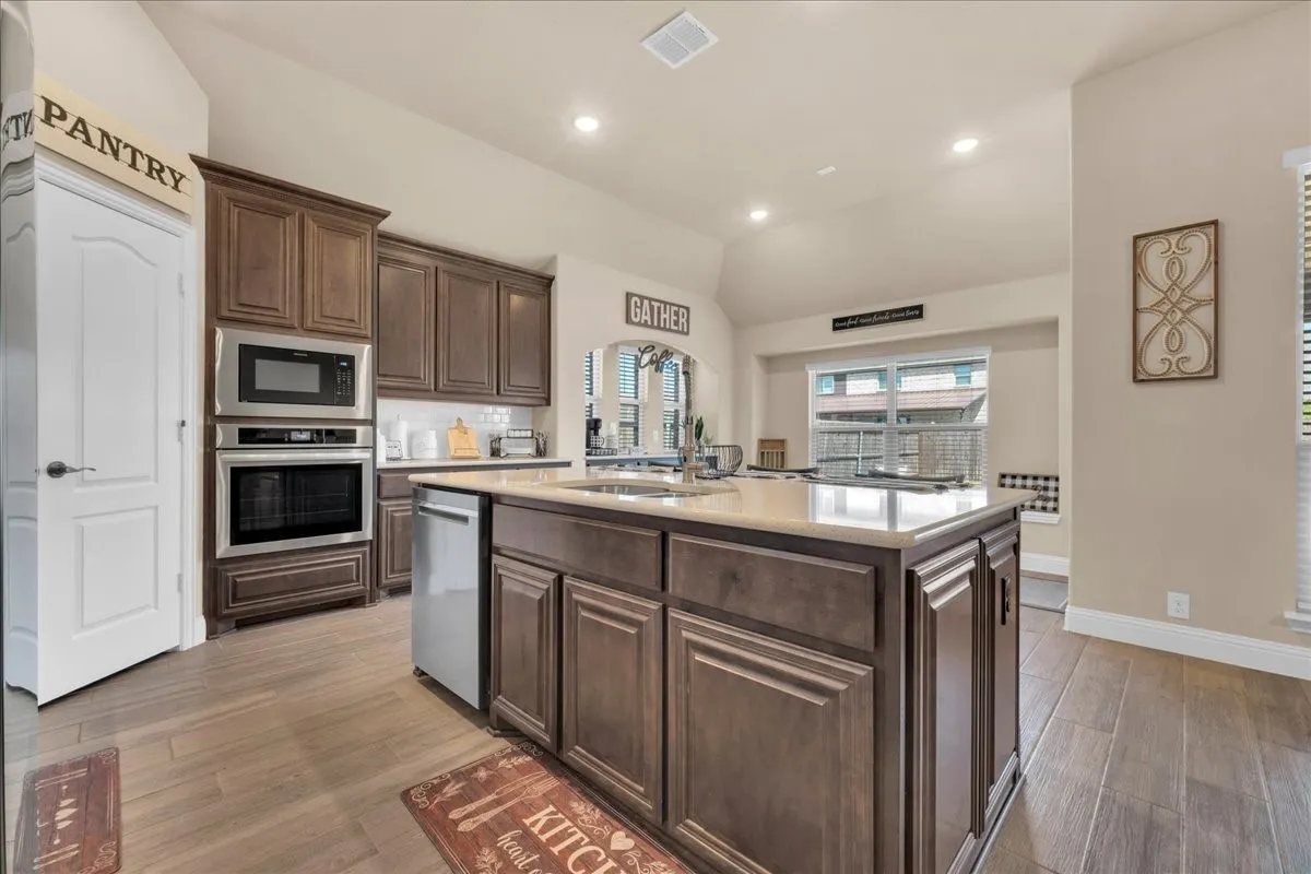 Kitchen featuring wood-finish flooring, recessed lighting, and a center island with a light-toned countertop