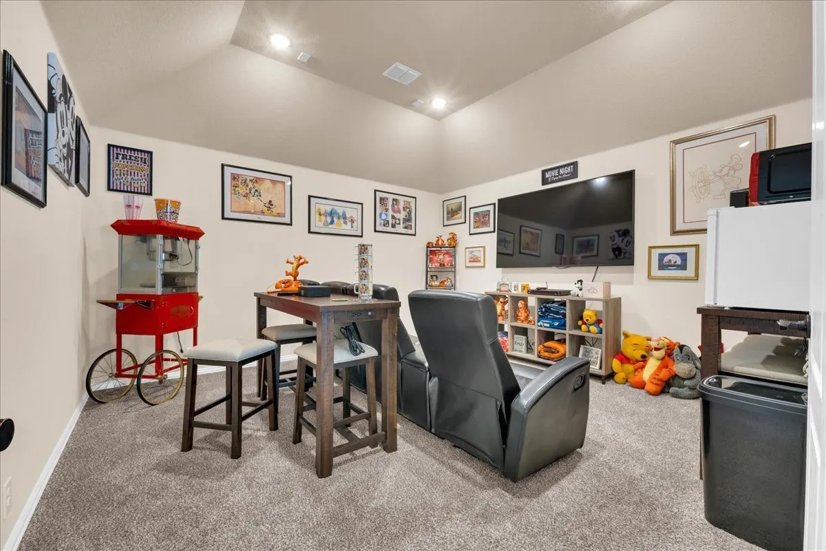 Recessed lighting, sloped ceiling, and soft gray carpeting