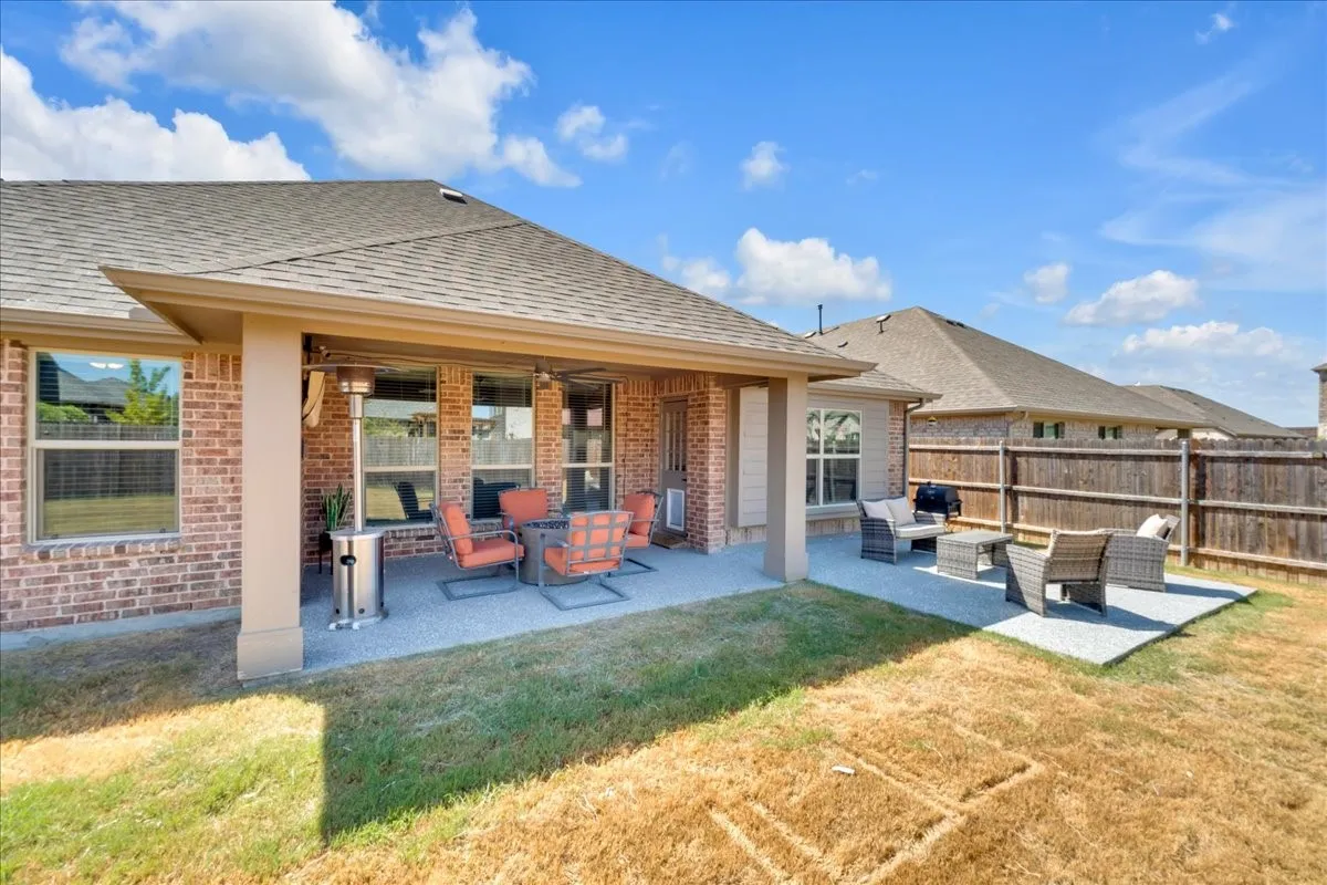 Brick exterior, covered patio, exposed aggregate patio surface, additional paver patio, wood privacy fencing