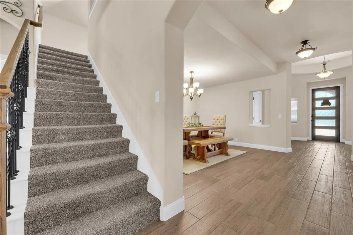 Staircase with wrought iron balusters and carpeted treads