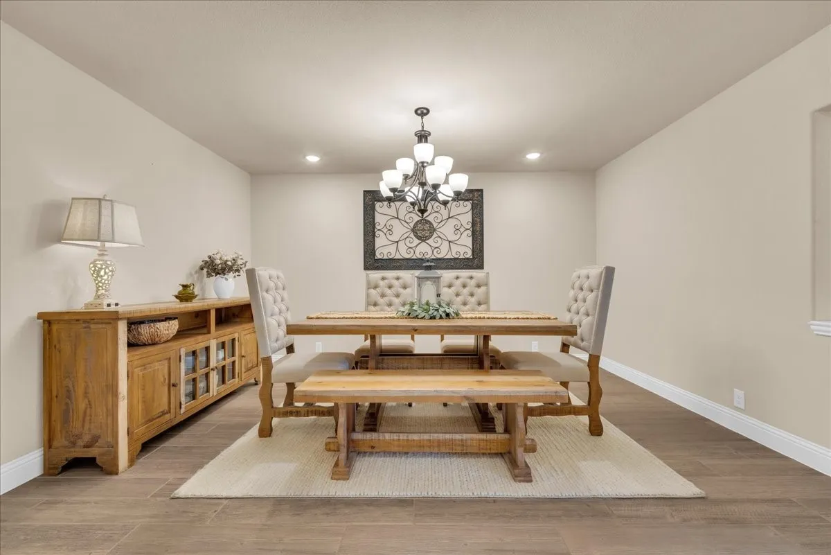 Recessed lighting, wood-finish flooring, and a chandelier with multiple lights