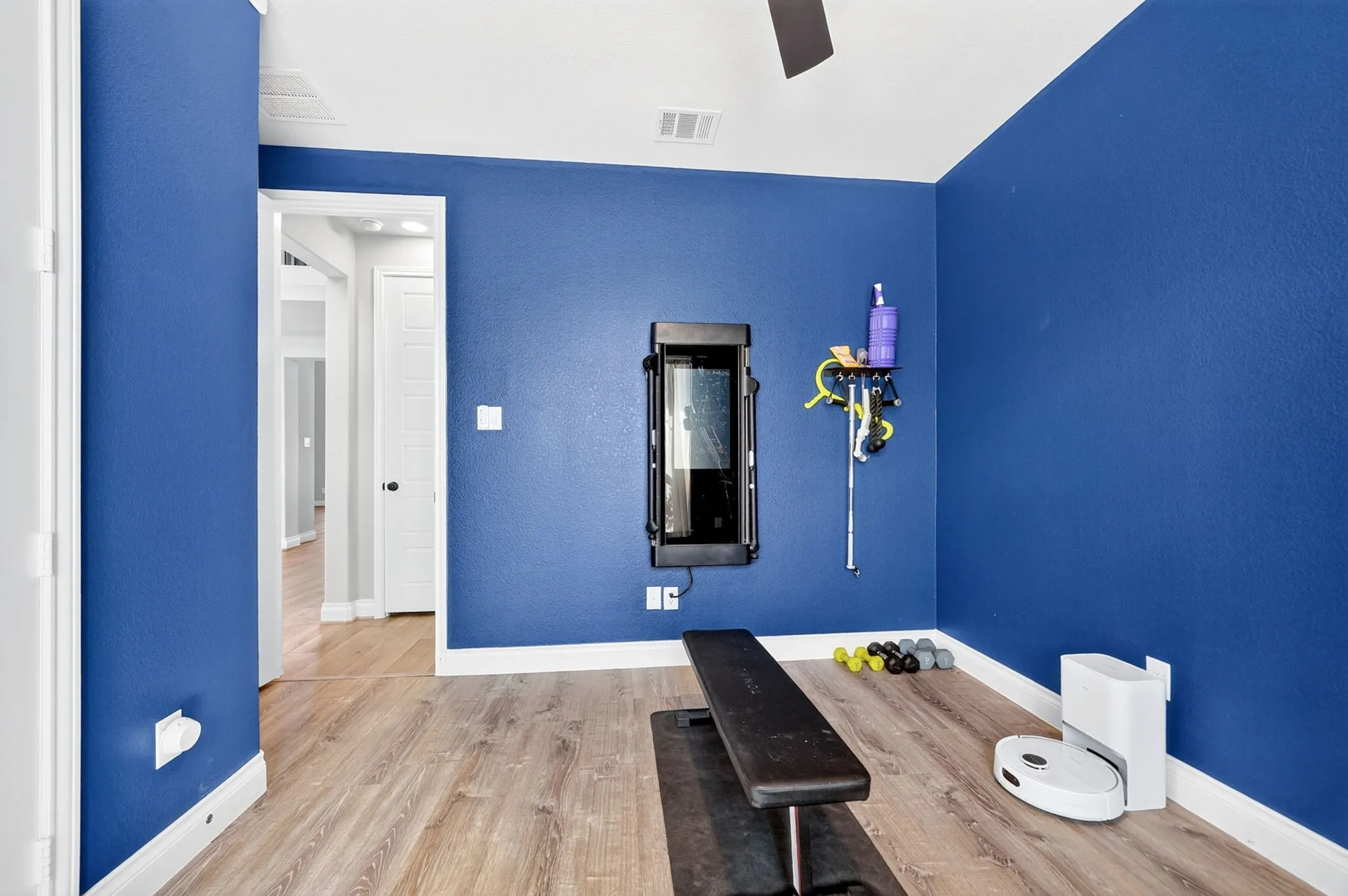 Vaulted ceiling with a ceiling fan, light wood-finish flooring, and white trim