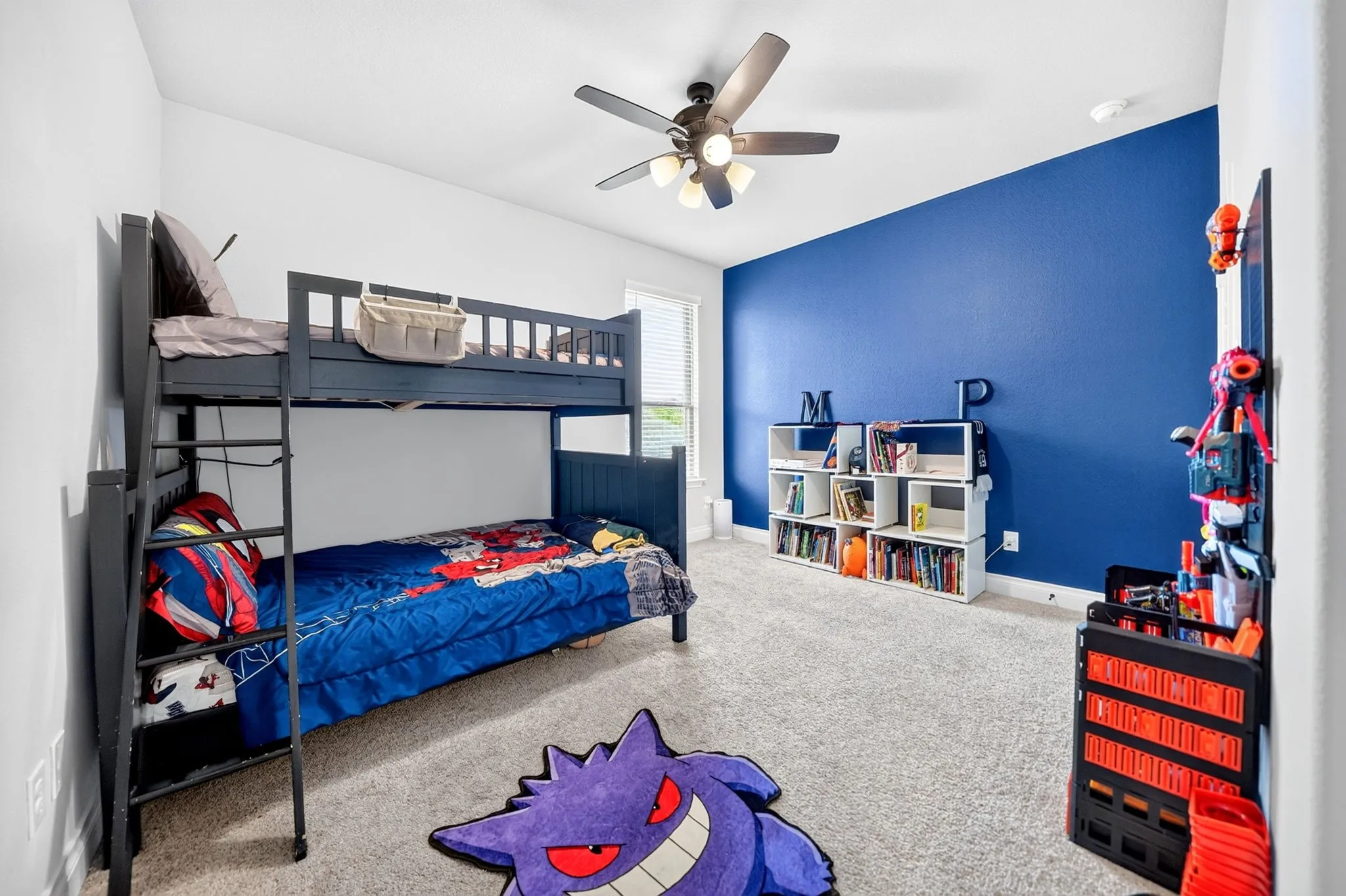 Room featuring a partial accent wall, carpeted flooring, window, and a ceiling fan with integrated lighting