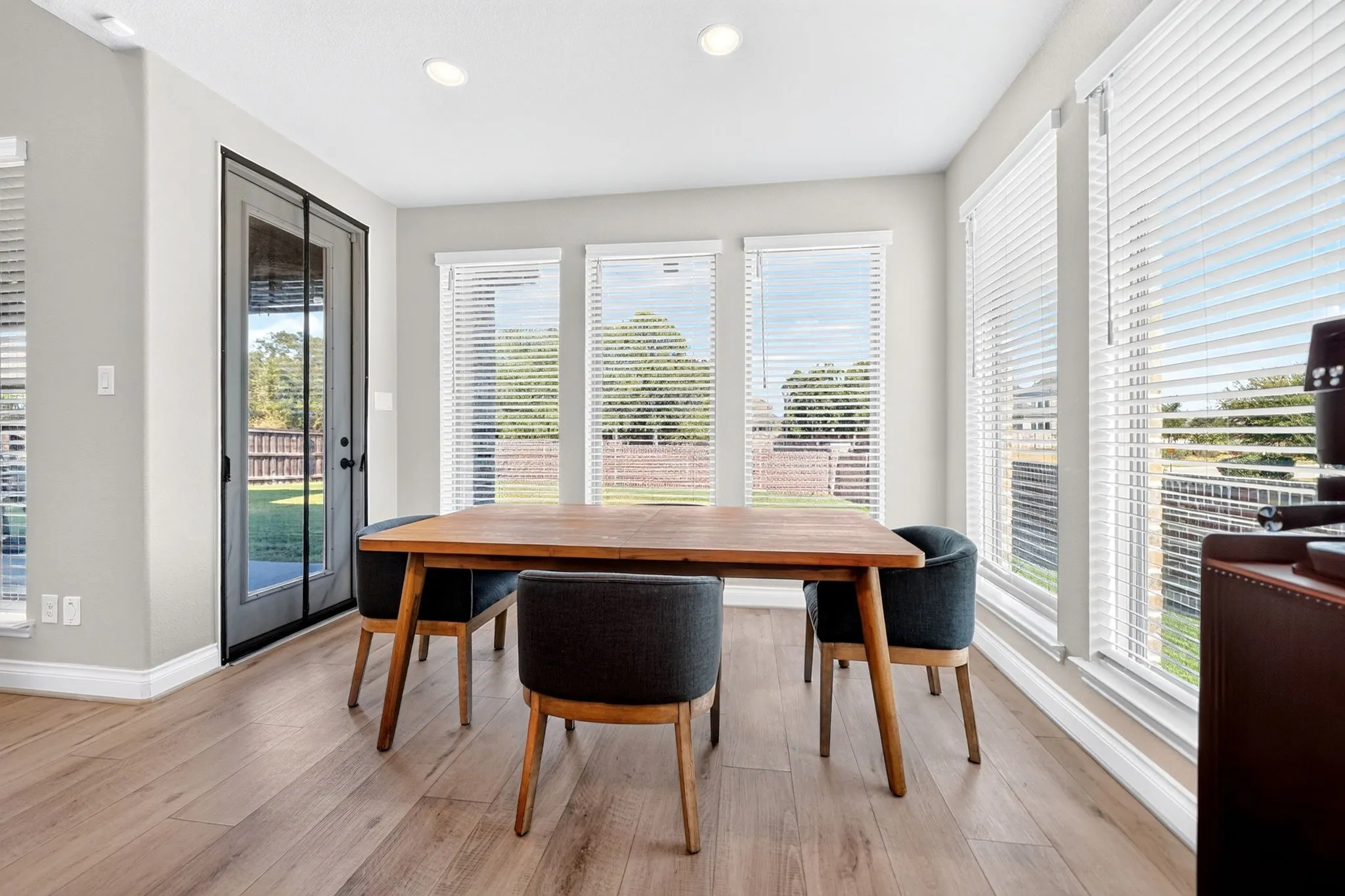 Light wood-finish flooring, recessed lighting, and a glass-paneled door