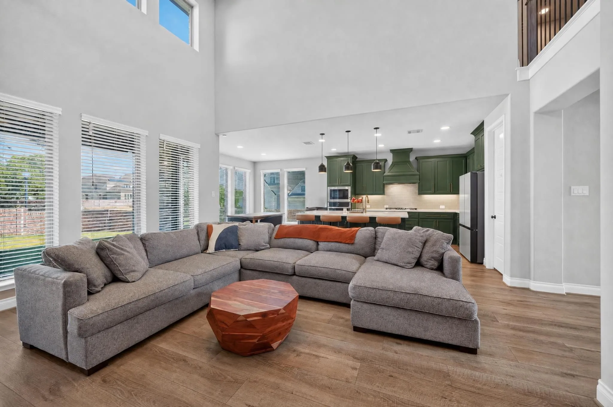 Two-story ceilings with high windows, wood-finish flooring, and recessed lighting