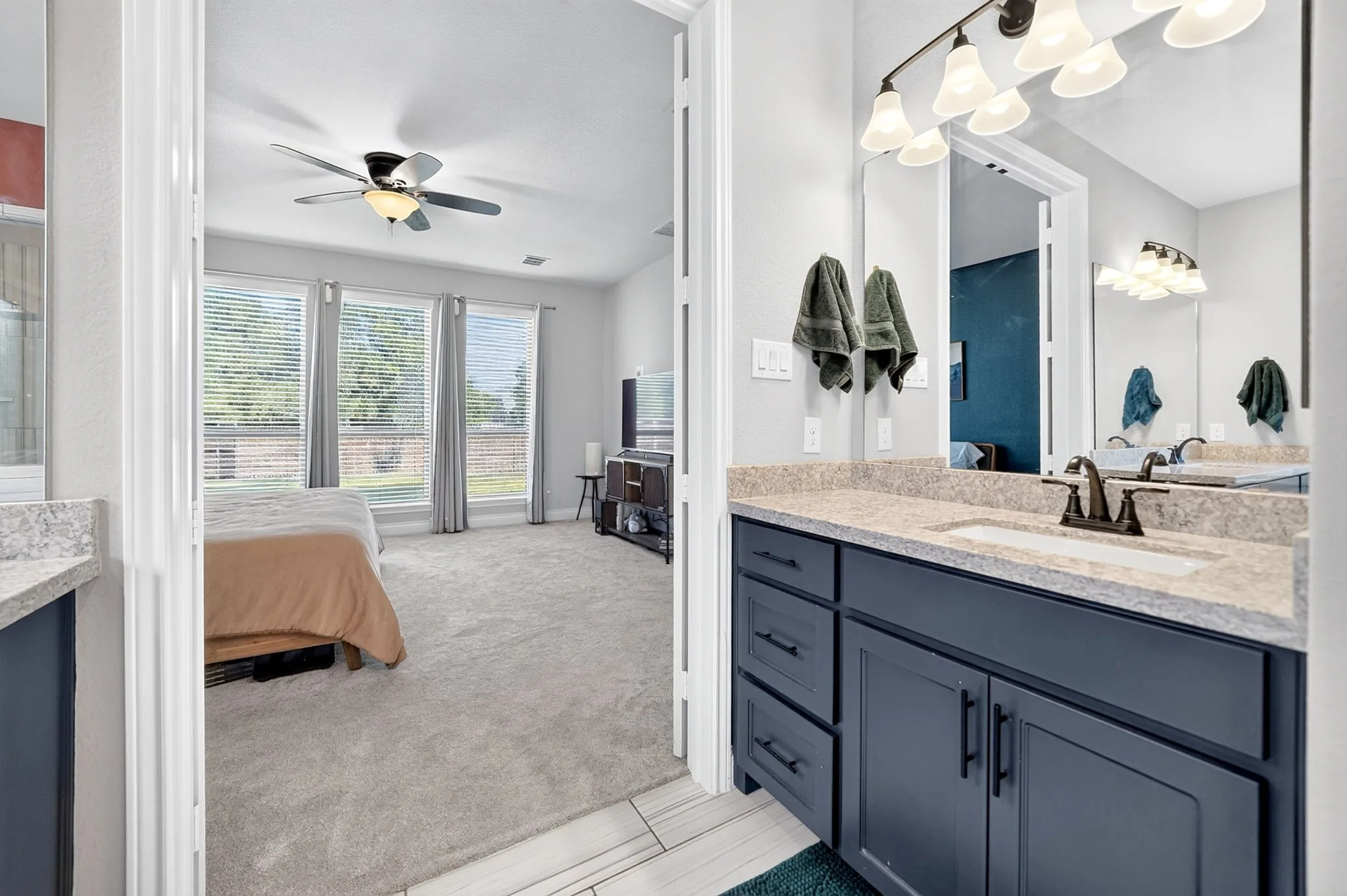 Bathroom vanity featuring a single basin, dark cabinetry, and speckled countertop