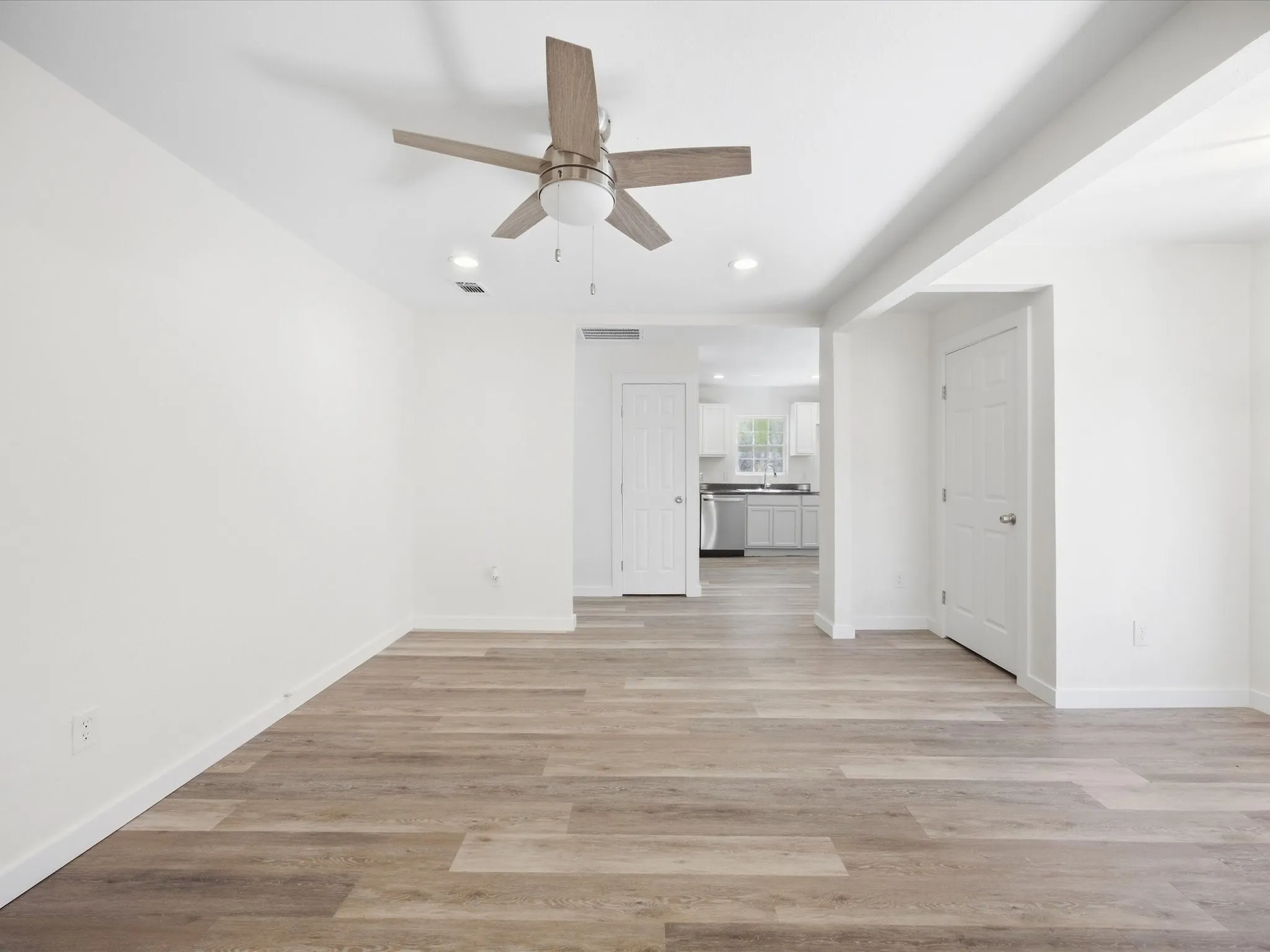 Wood-finish flooring, recessed lighting, and a ceiling fan with integrated lighting