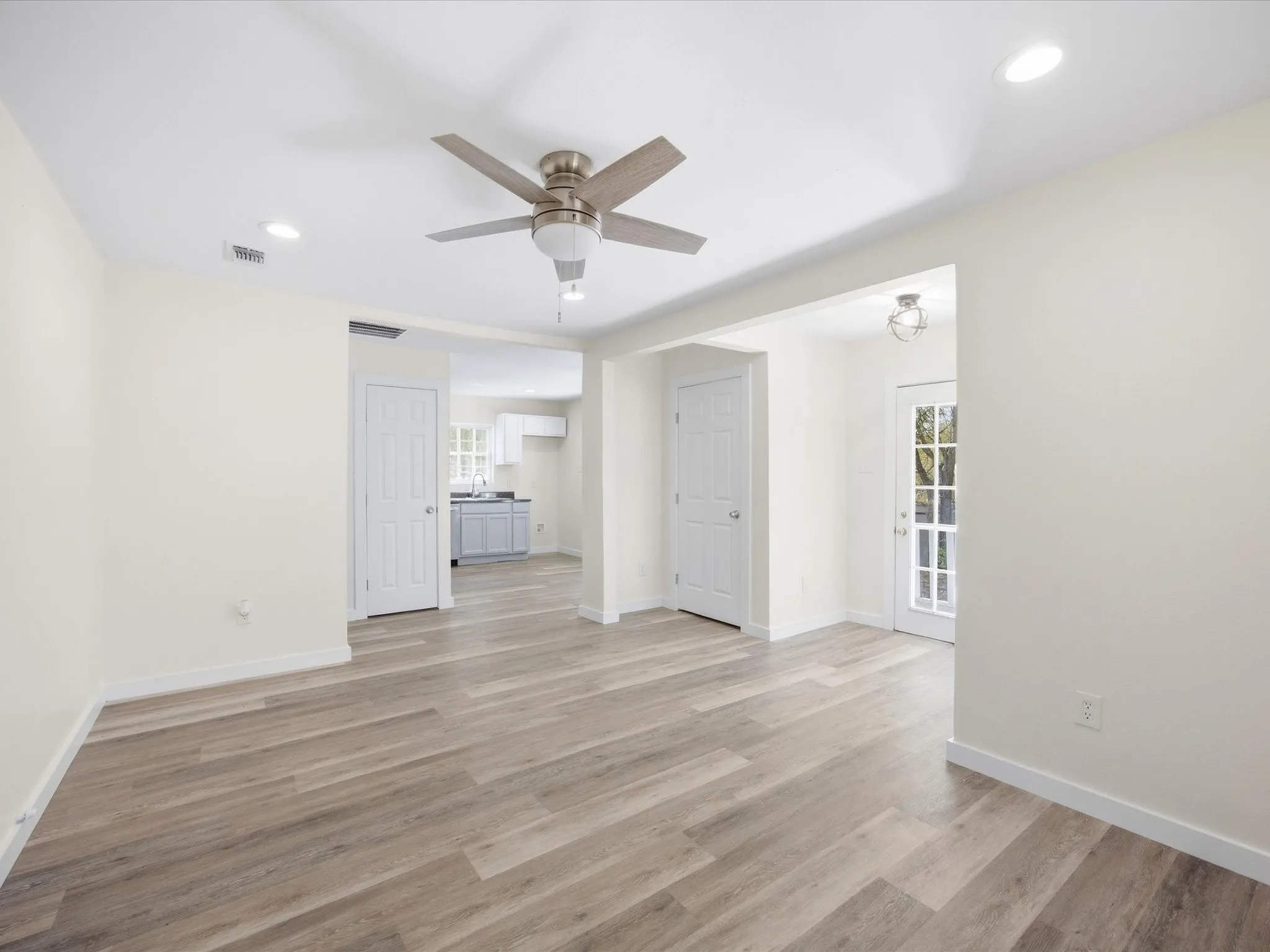 Wood-finish flooring, recessed lighting, and a ceiling fan with integrated lighting